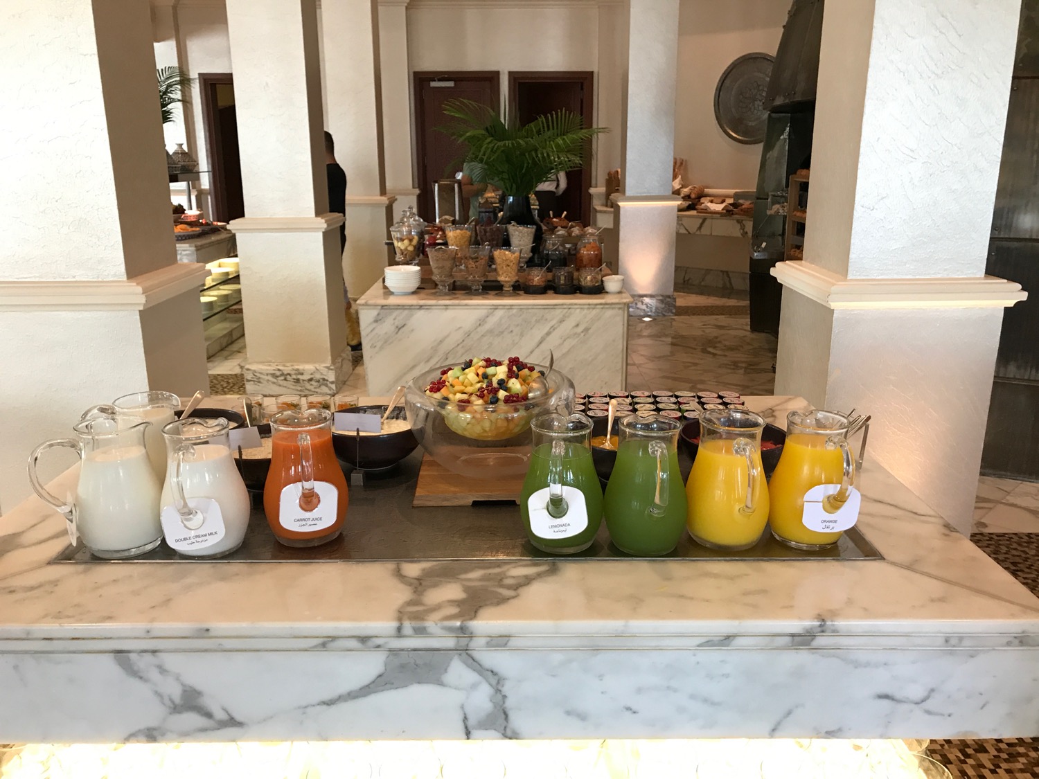 a buffet table with different drinks and bowls of food