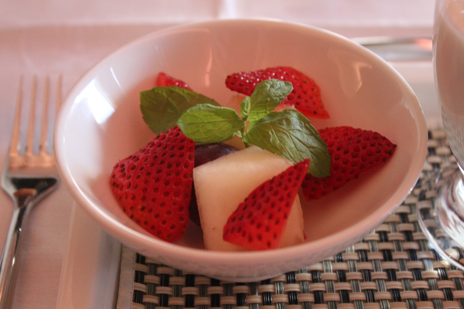 a bowl of fruit with strawberries and mint