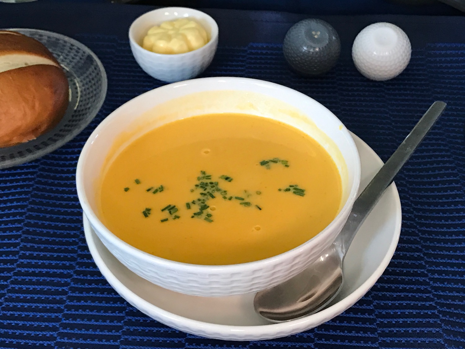 a bowl of soup with a spoon and a bowl of butter