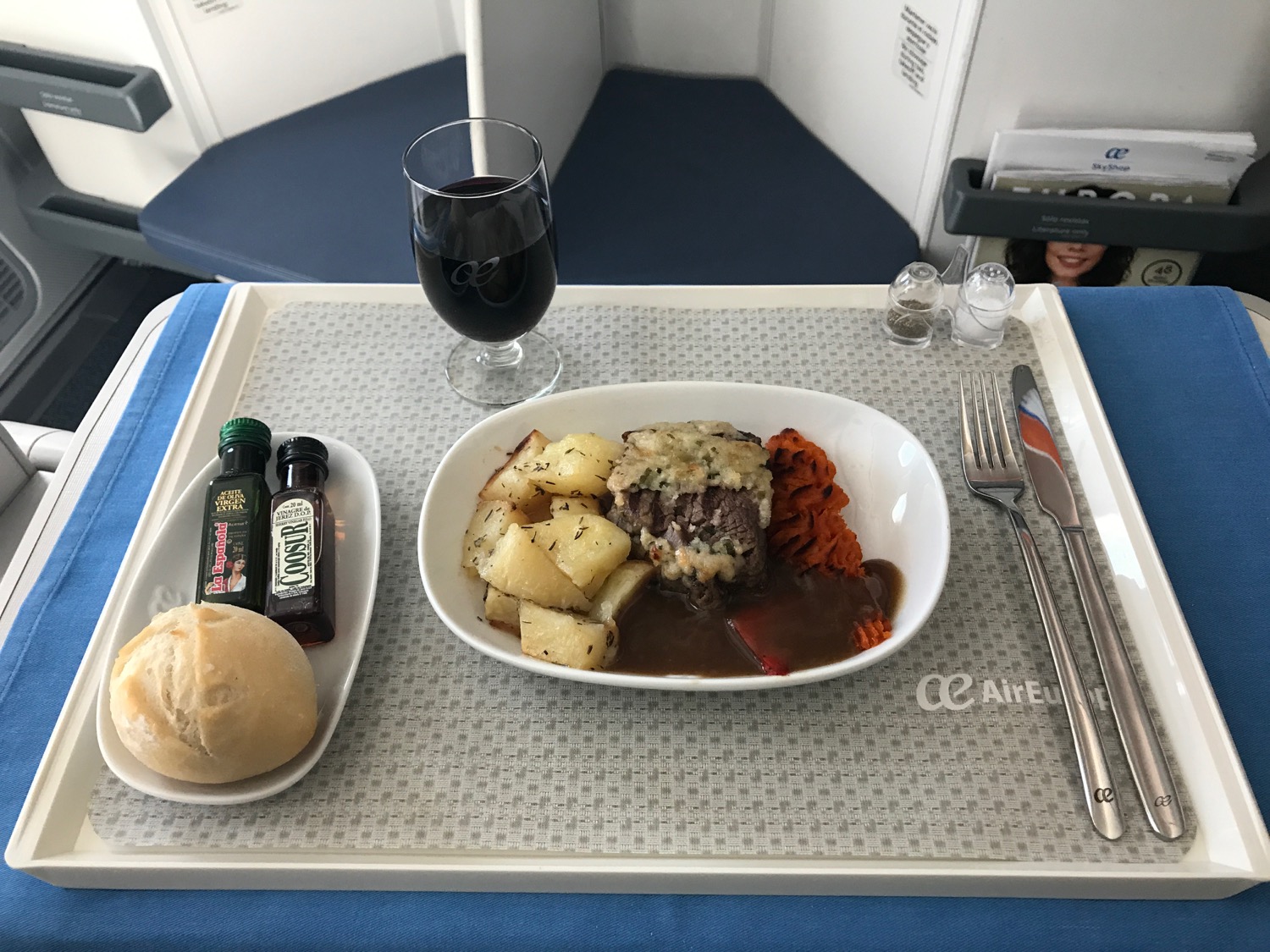 a tray with food and a glass of wine