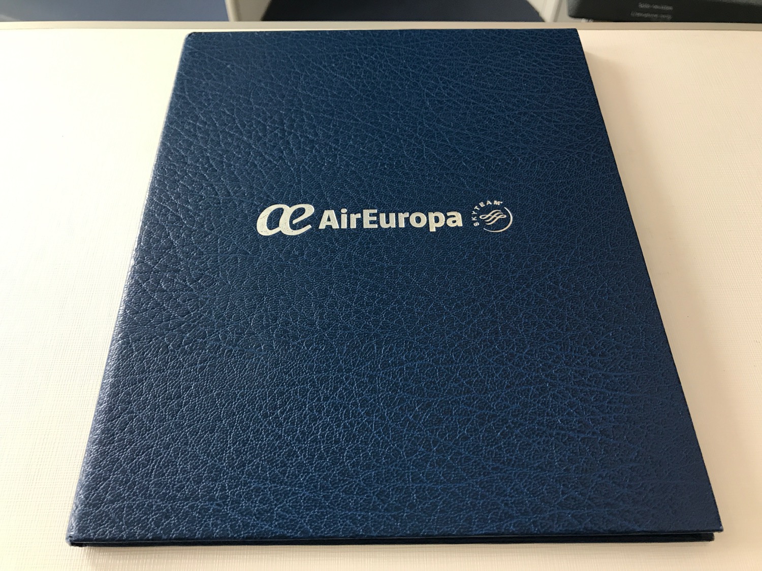 a blue leather folder with white text on it