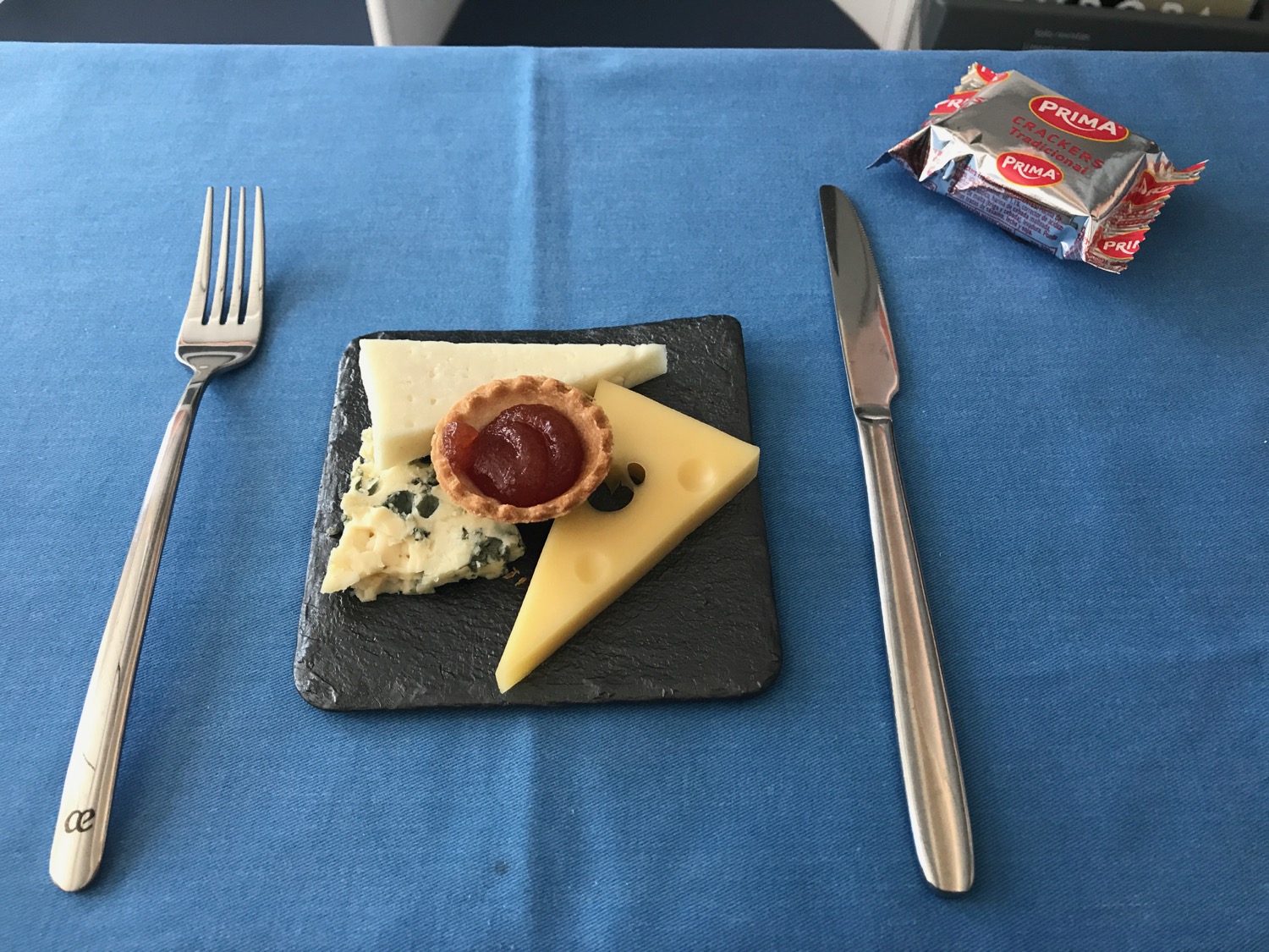 a plate of cheese and jam on a blue table