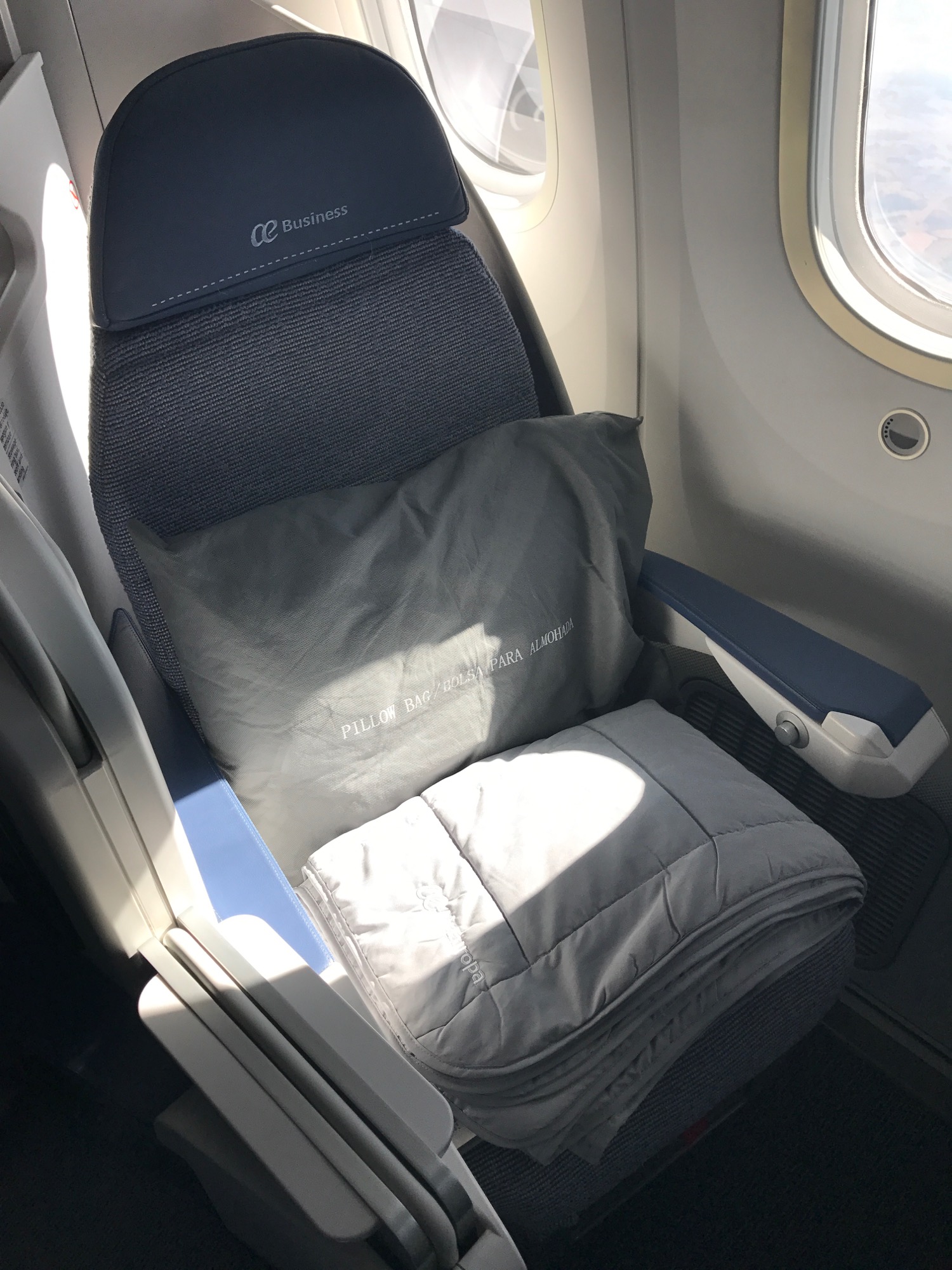 a seat with a pillow and a blanket in the middle of the seat