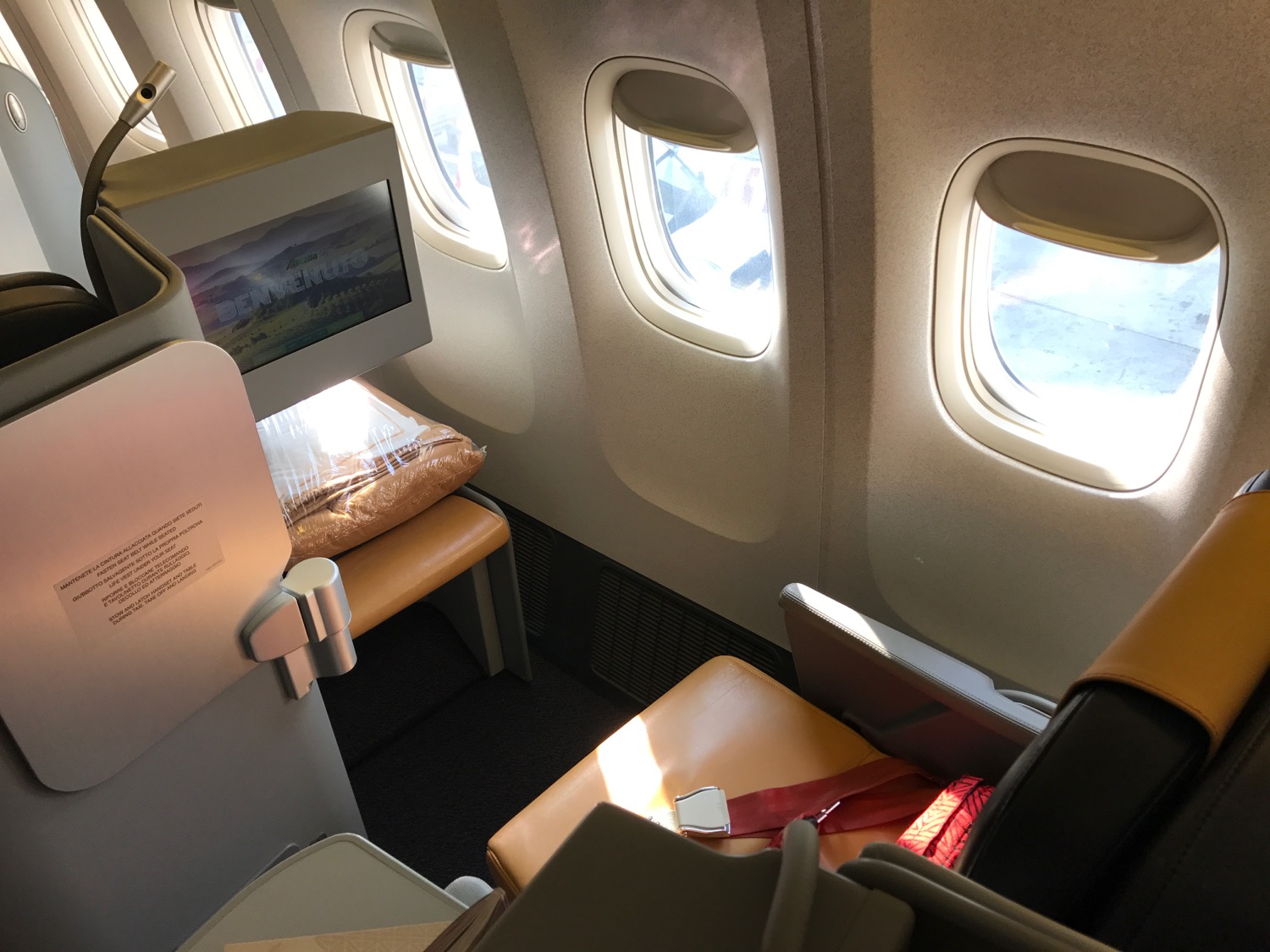 an airplane seat with windows and a television