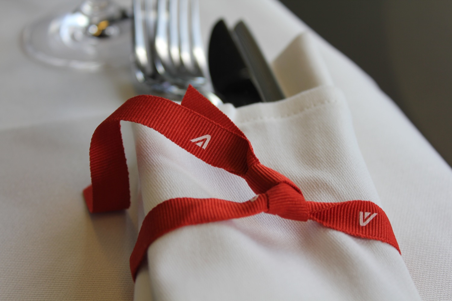 a fork and knife wrapped in a red ribbon