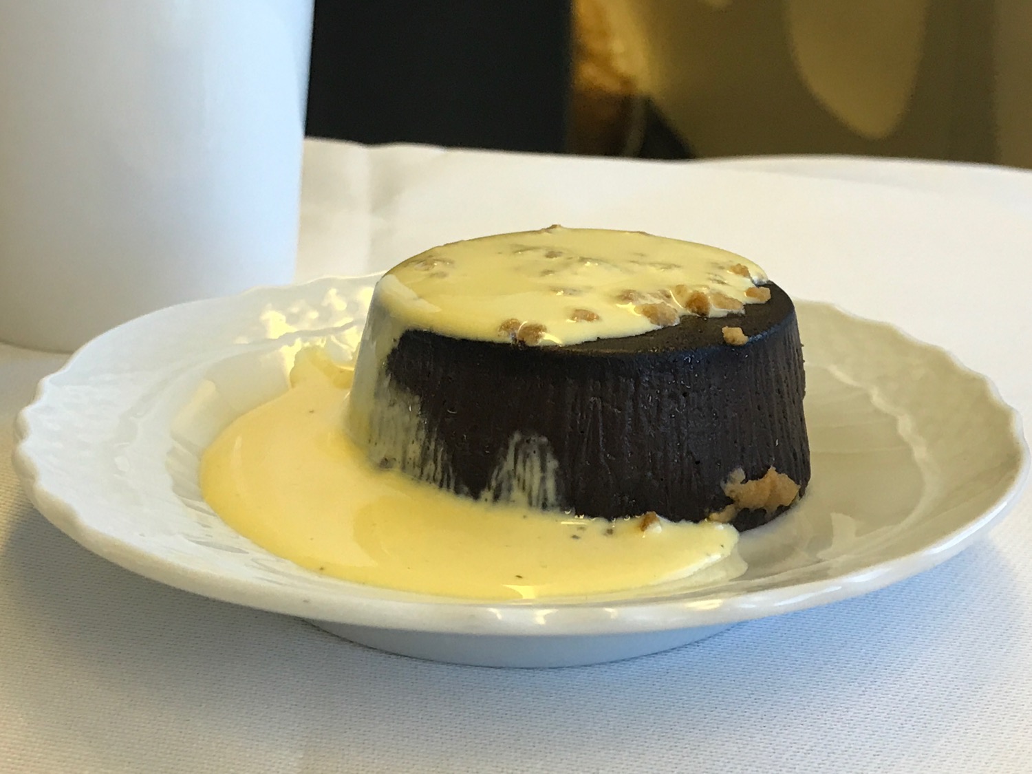 a chocolate pudding with a white sauce on a white plate