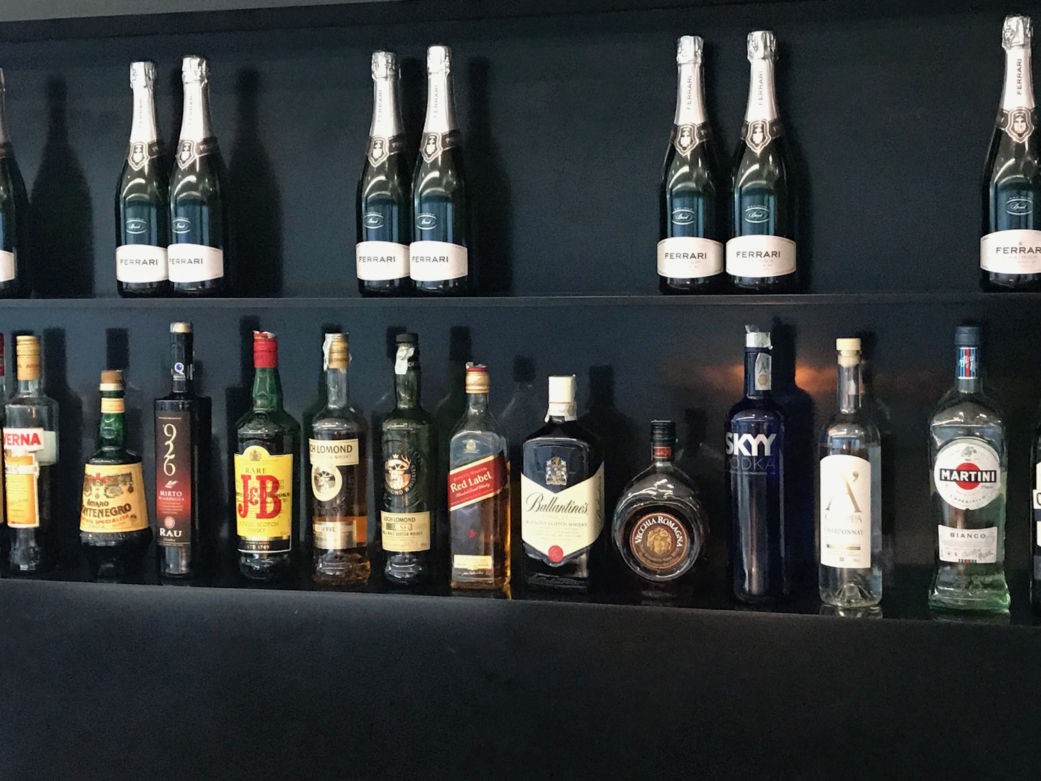 a shelf with bottles of alcohol