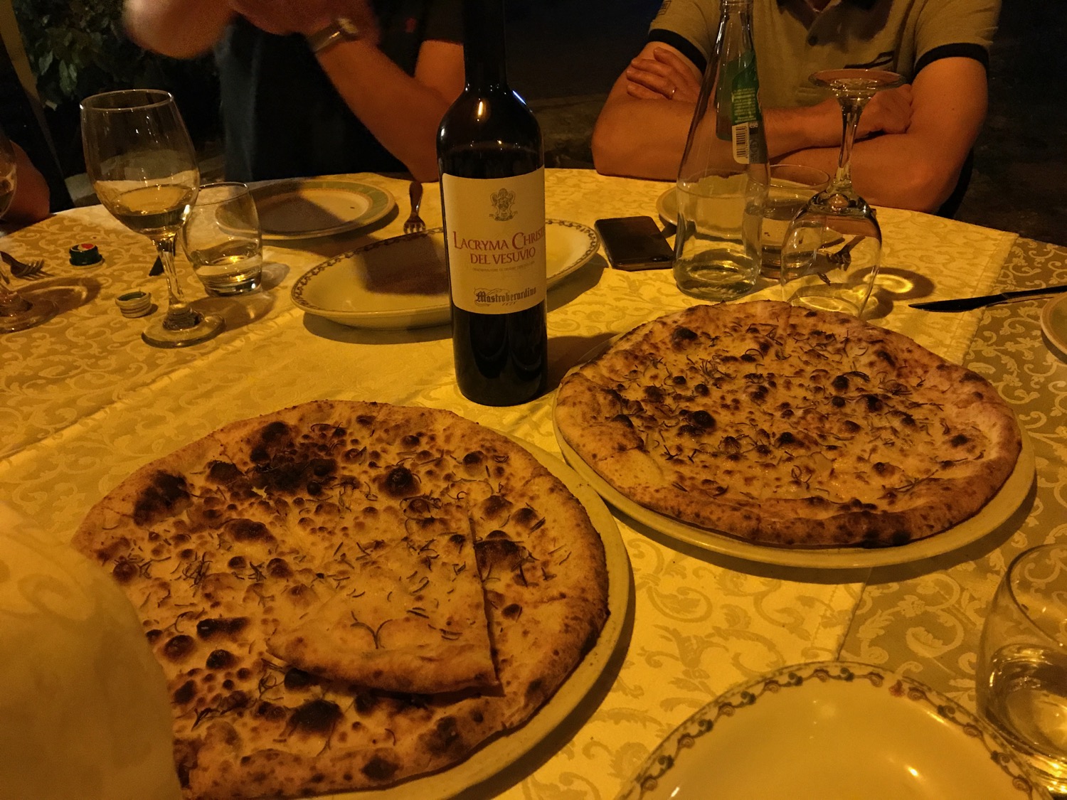 a table with plates of pizza and wine