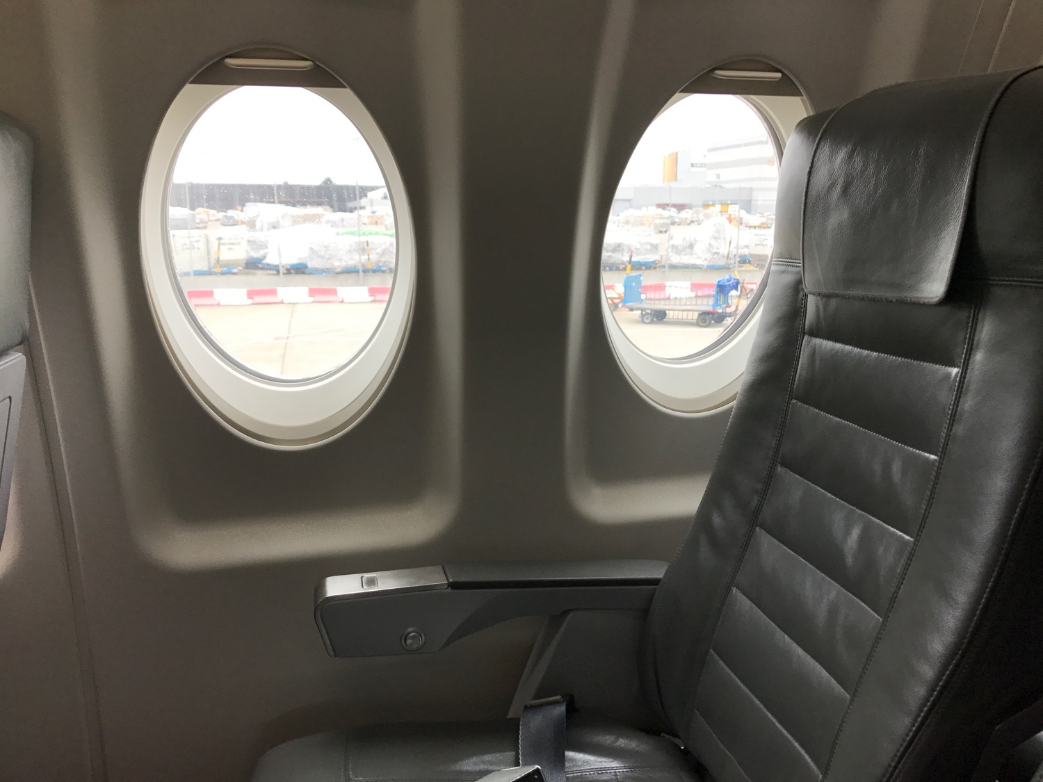a seat in an airplane with oval windows