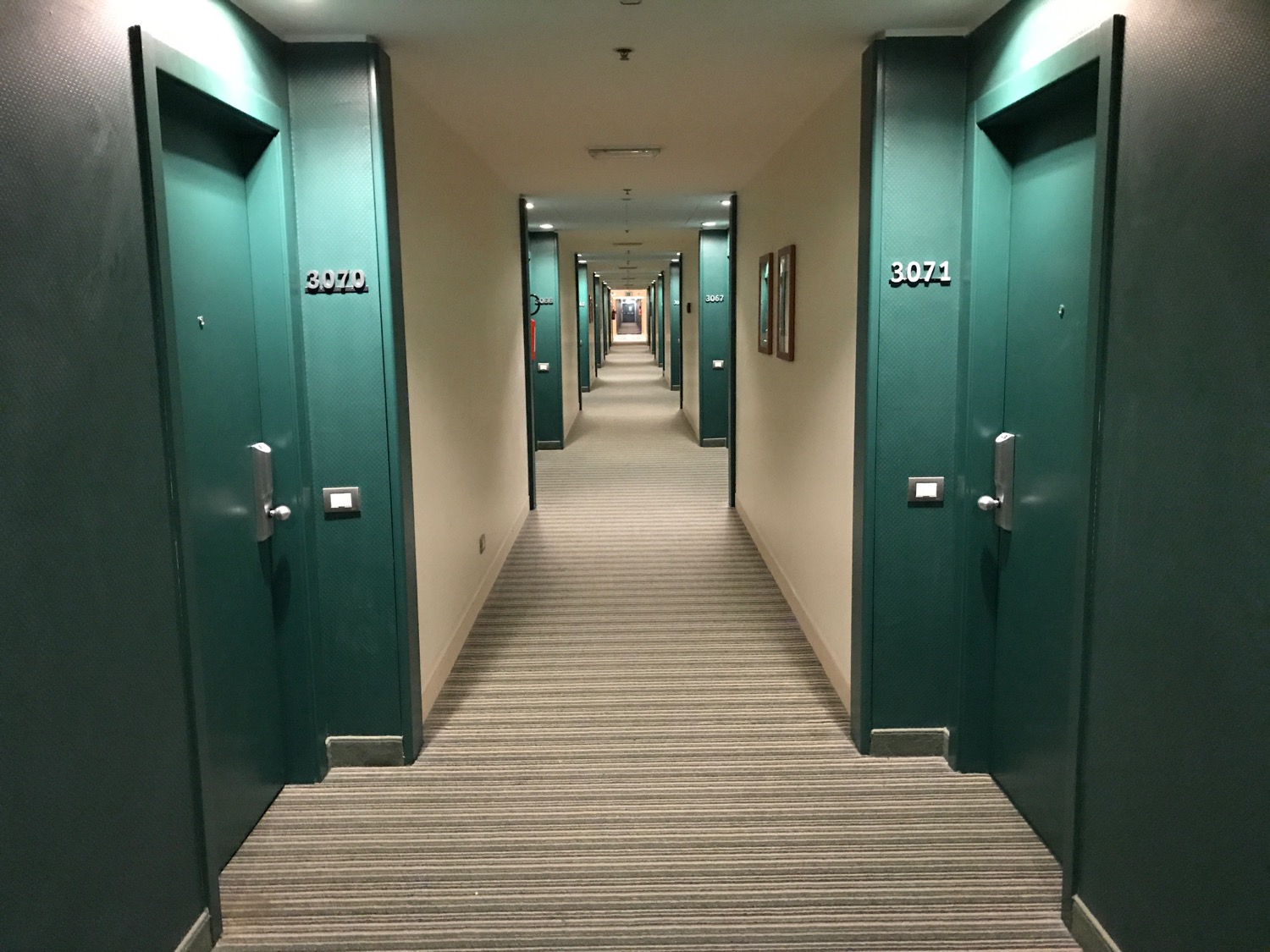 a hallway with green doors