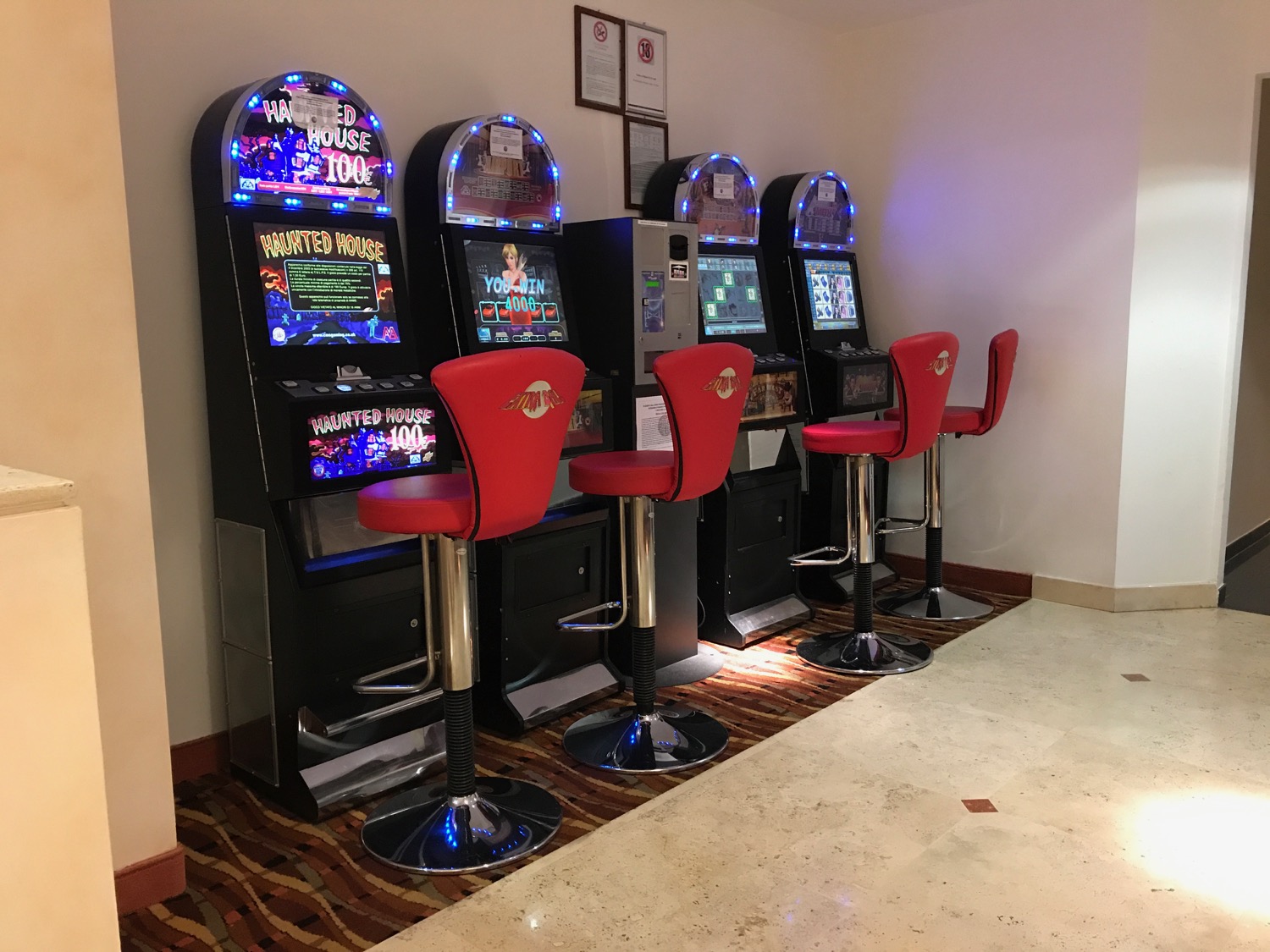 a row of slot machines with red chairs