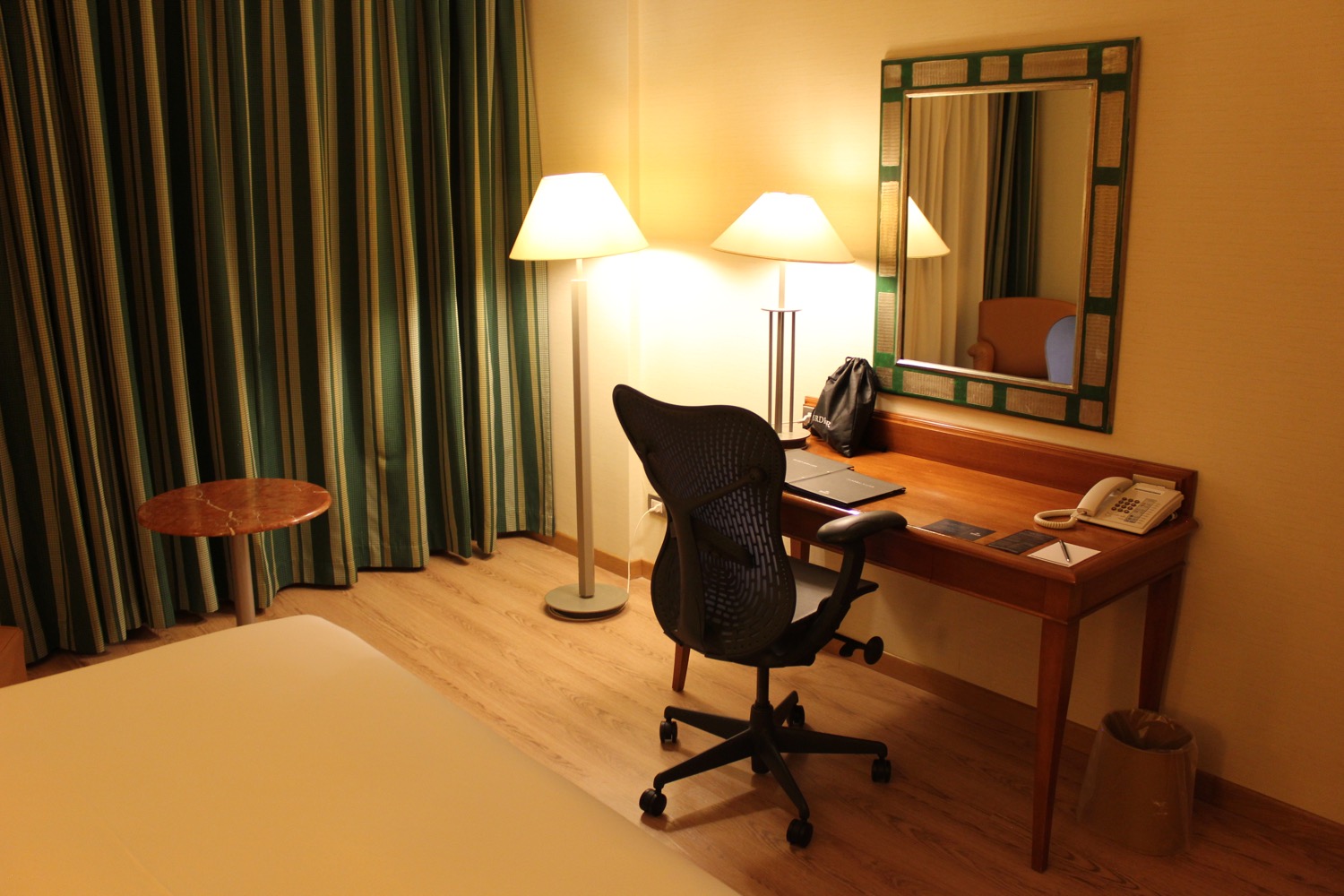 a desk with a chair and a lamp in a hotel room