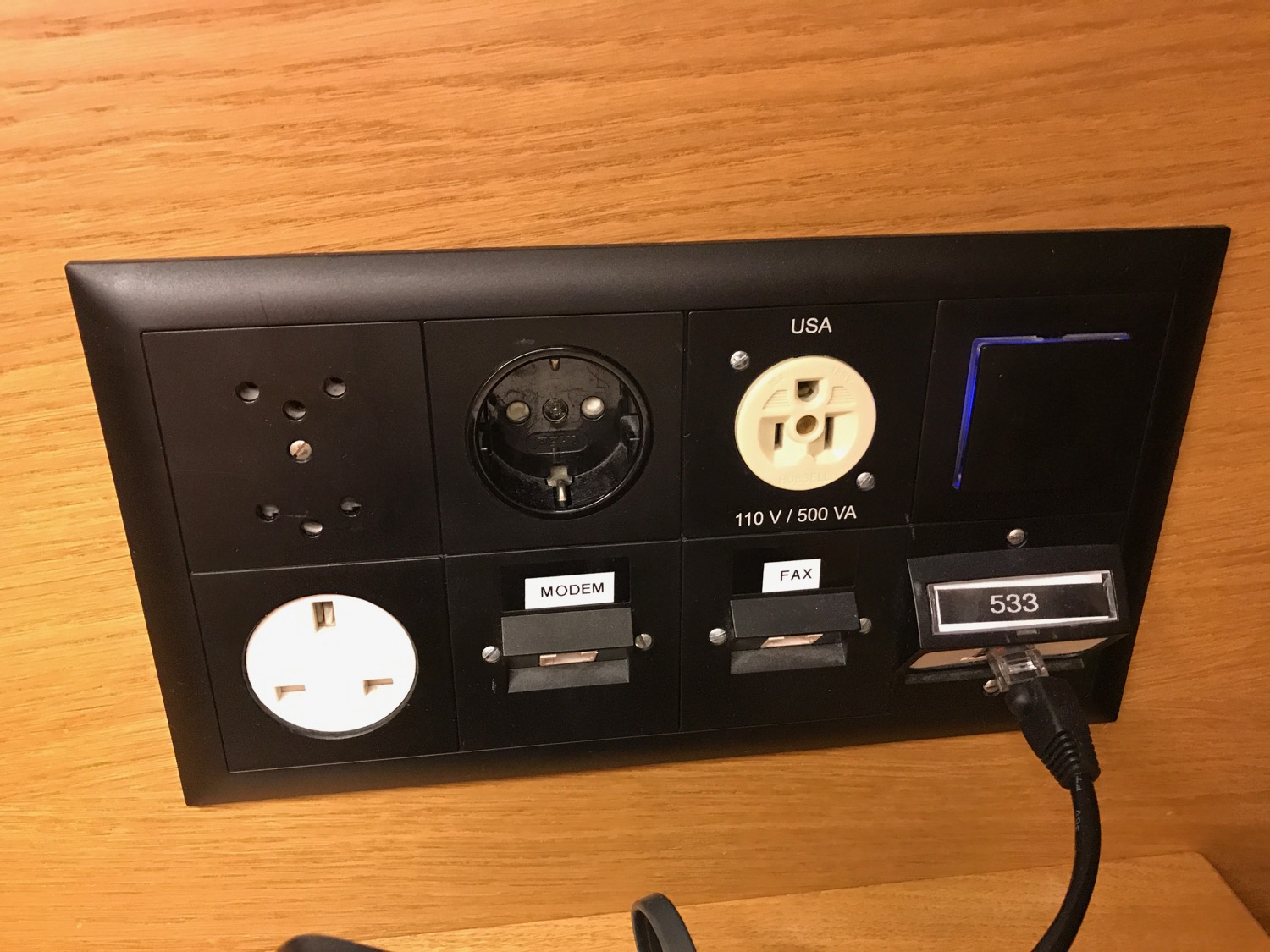 a black rectangular outlet with buttons and plugs