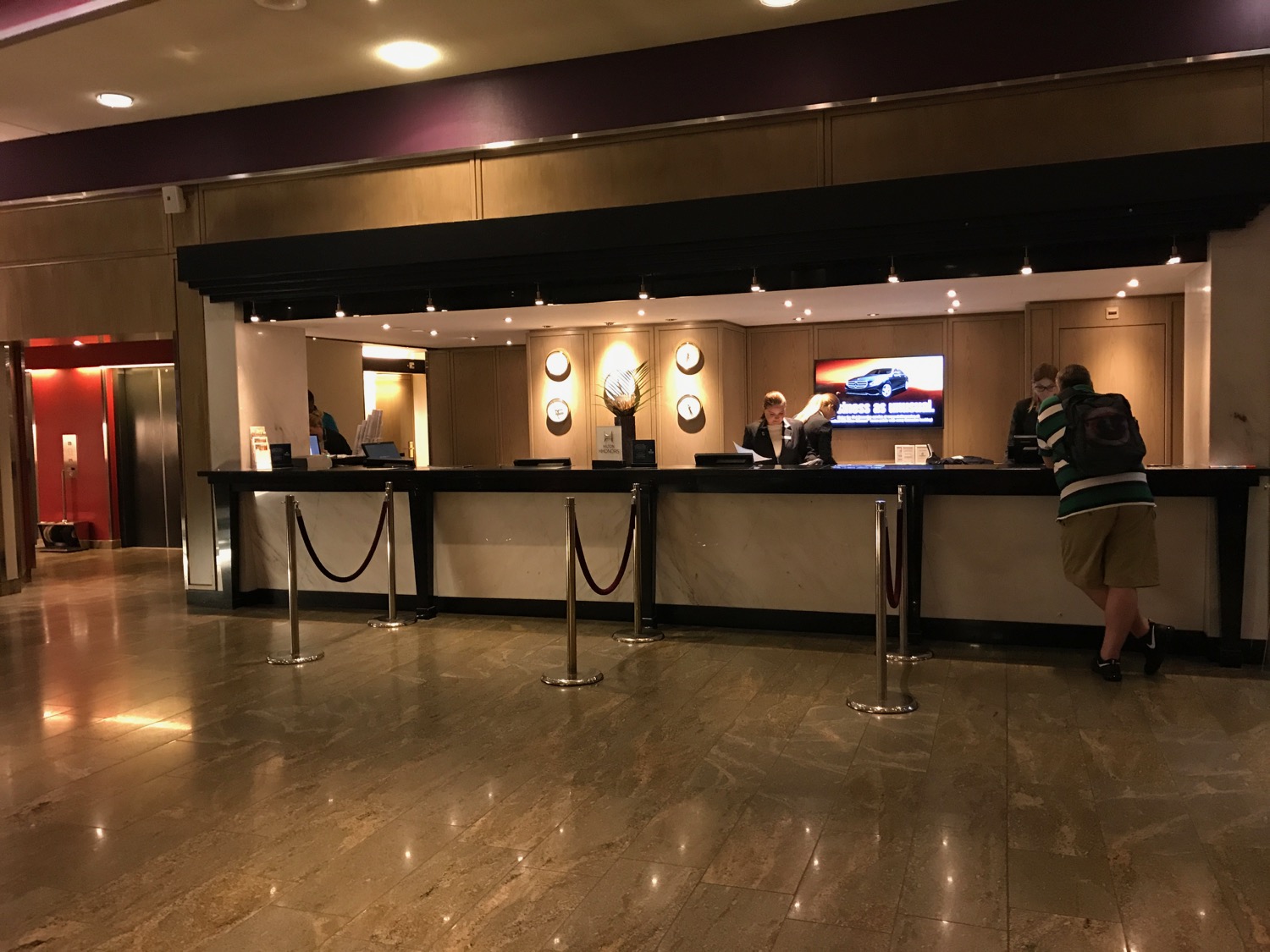 a hotel reception desk with people standing in front of it