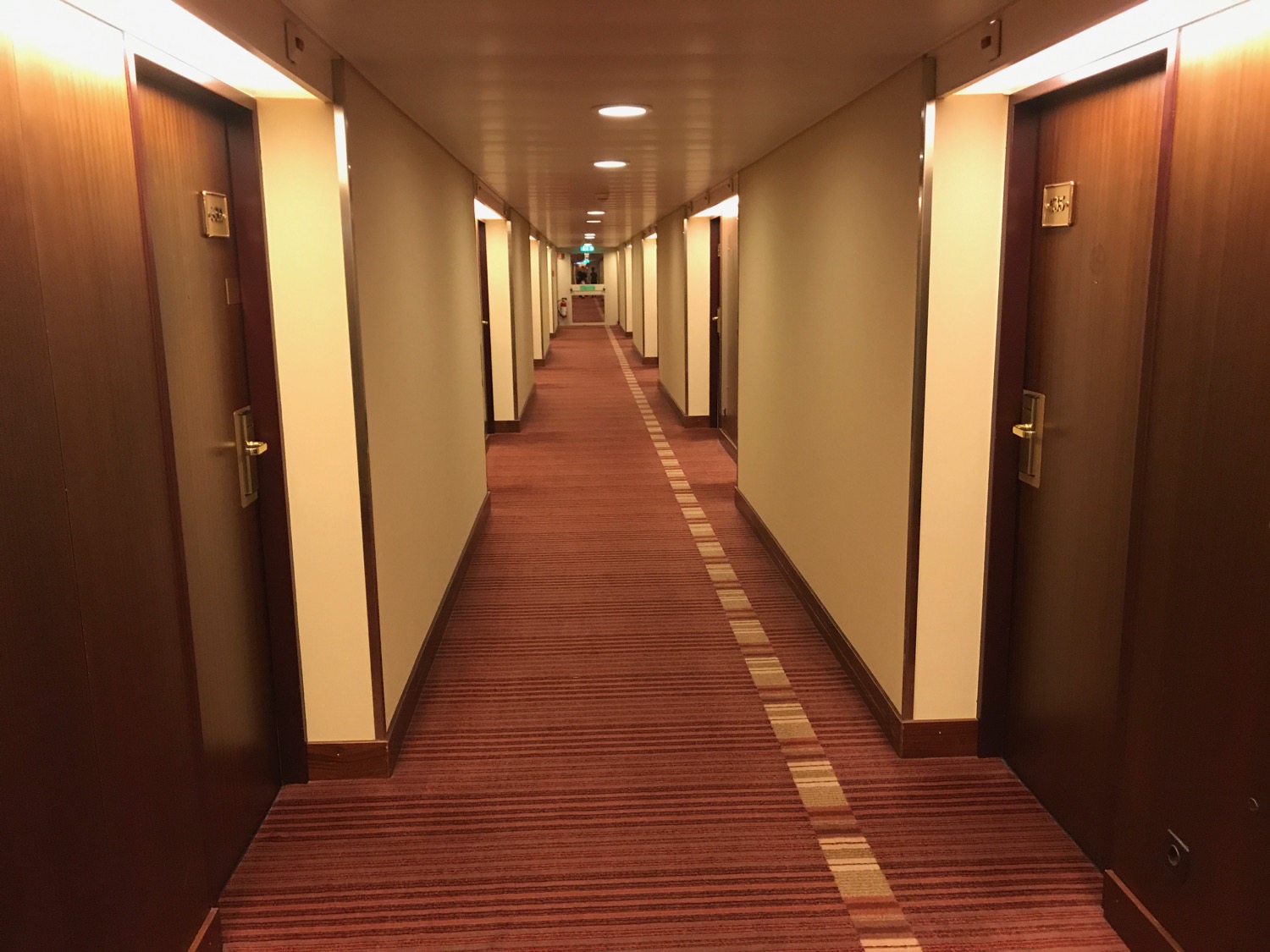 a hallway with doors and a red carpet