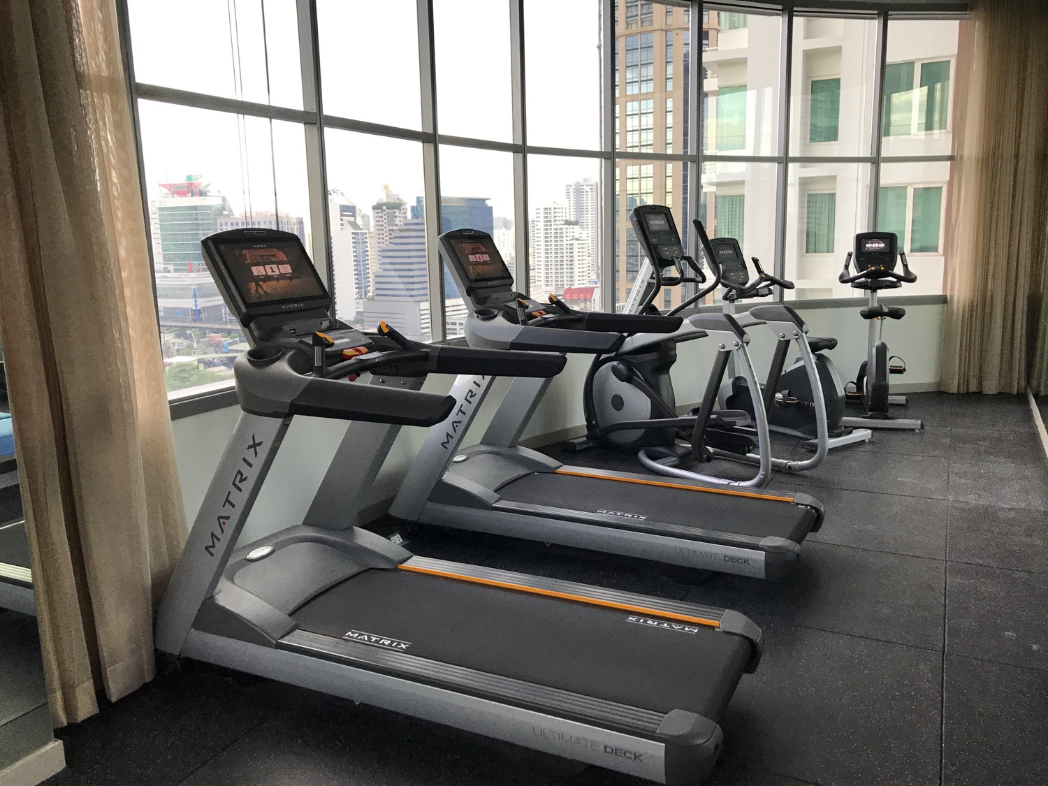 a group of treadmills in a room with windows