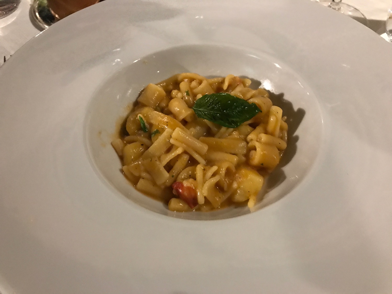 a plate of pasta with a leaf on top