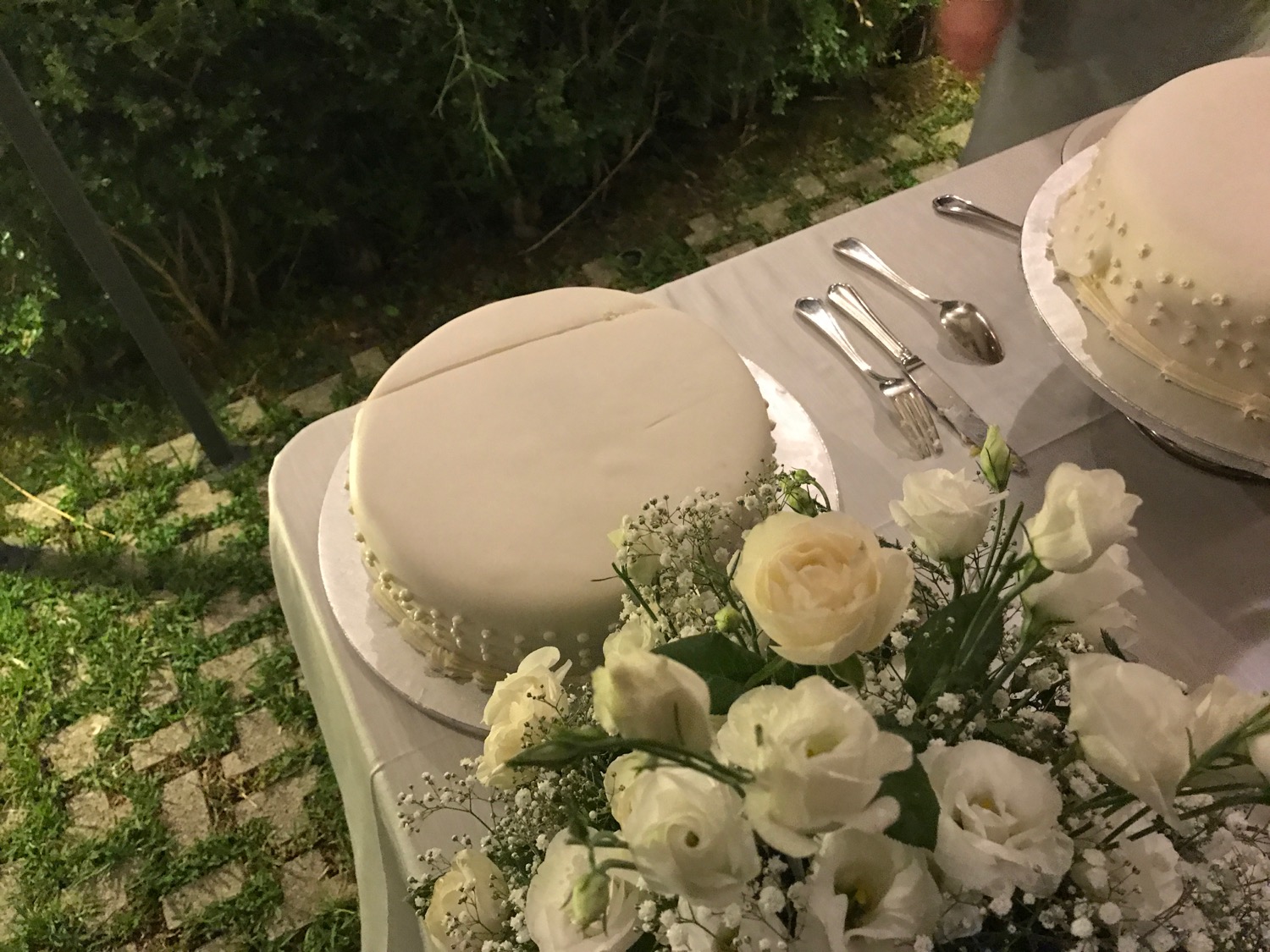 a white cake on a table with flowers