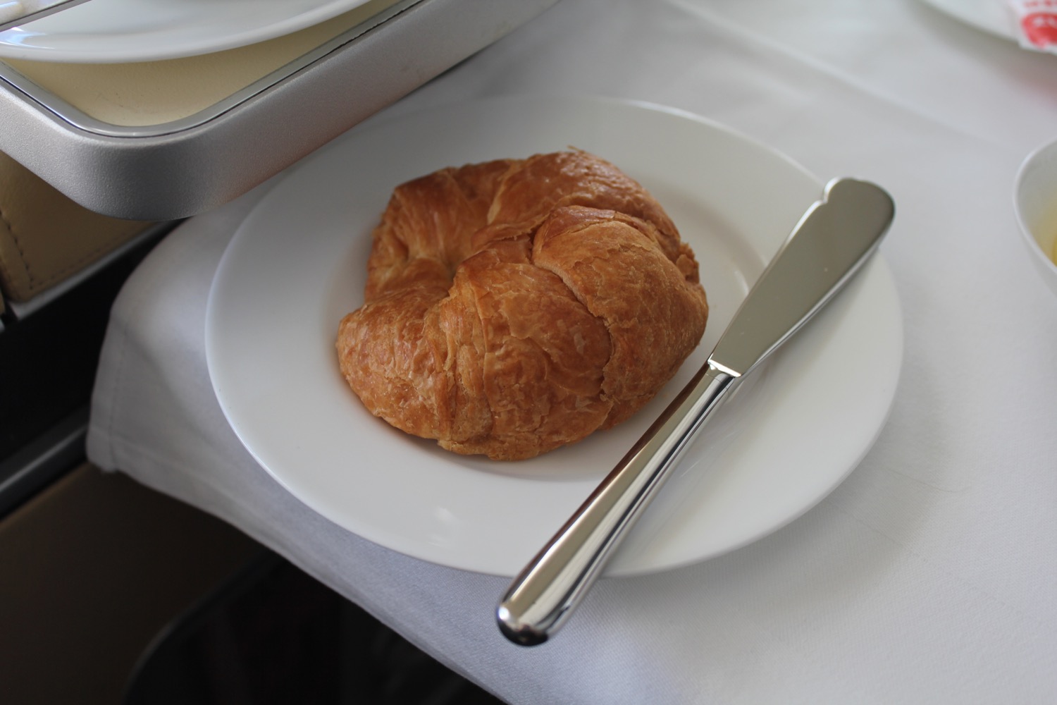a croissant on a plate with a knife