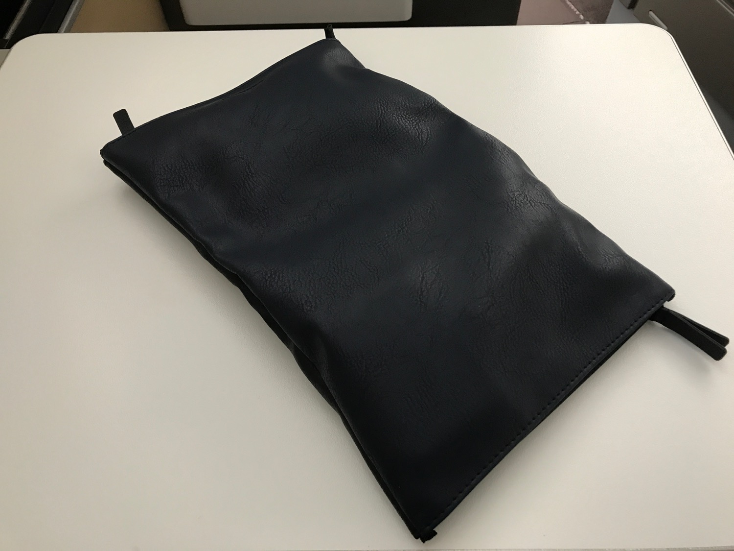 a black leather pouch on a white surface