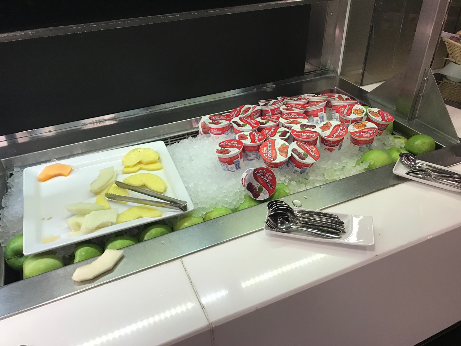 a tray of yogurt and fruit on ice