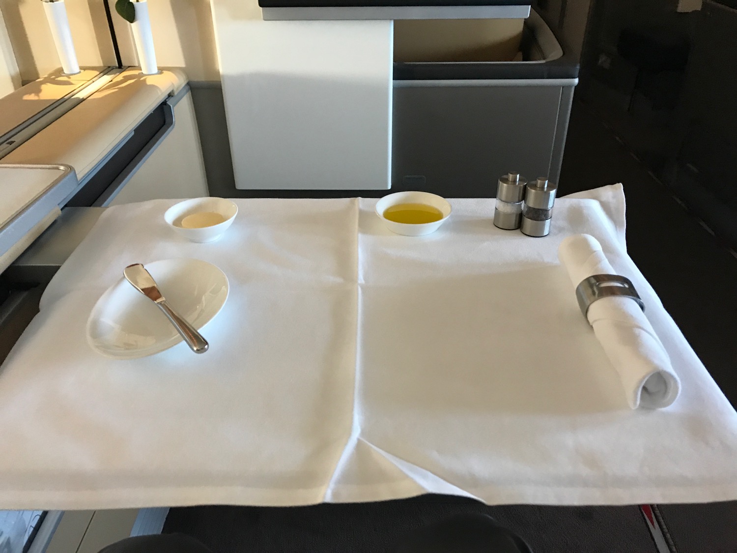 a table with a white cloth napkin and a plate with a fork and knife