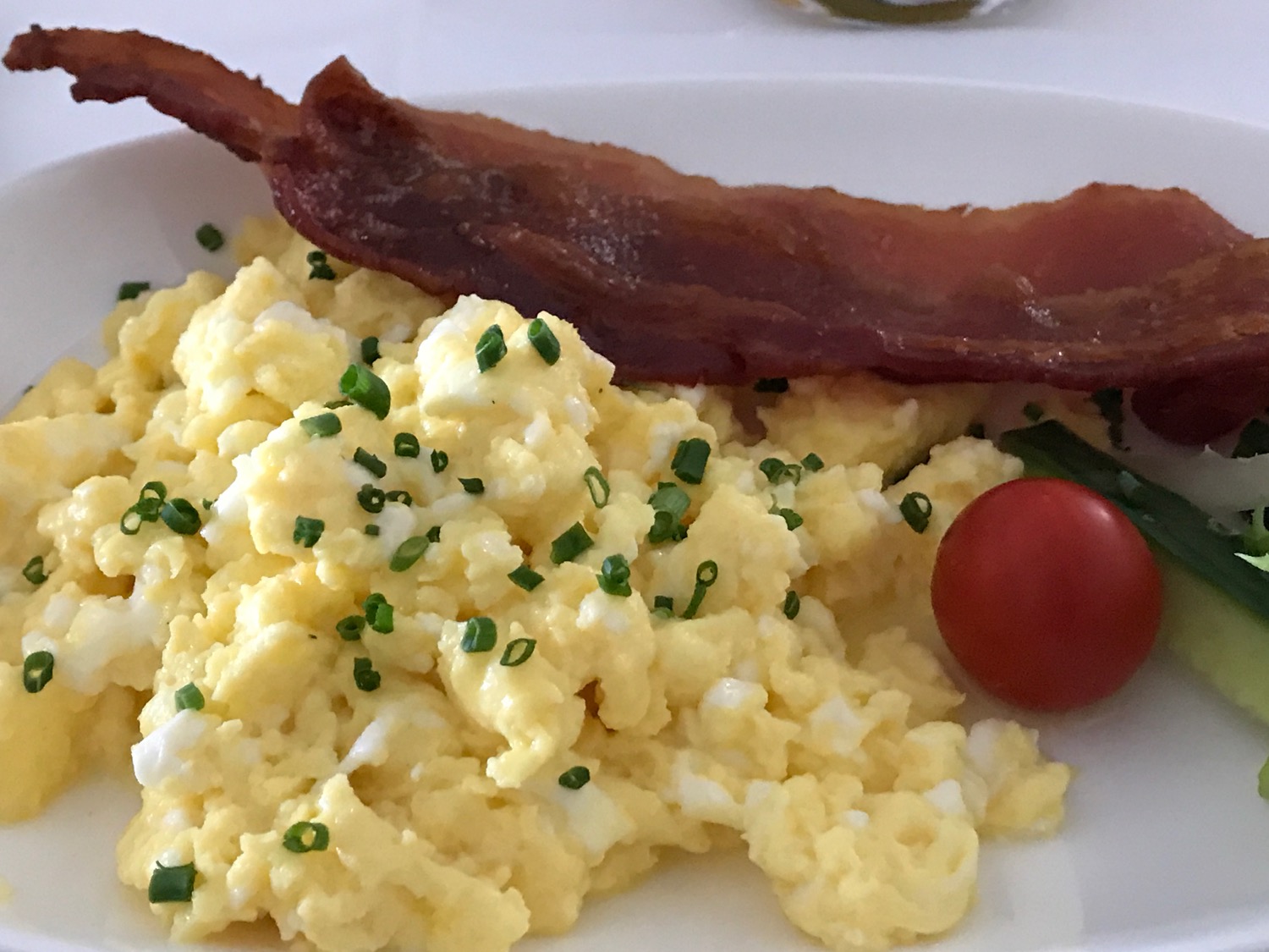 a plate of scrambled eggs and bacon