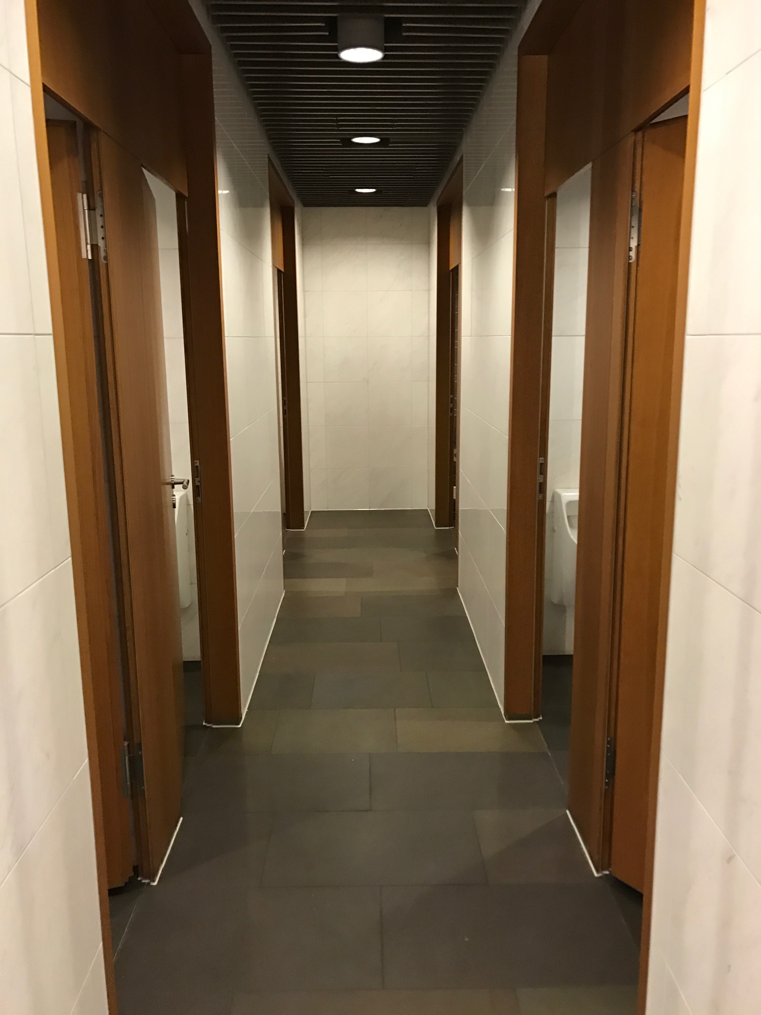 a hallway with doors and a urinal