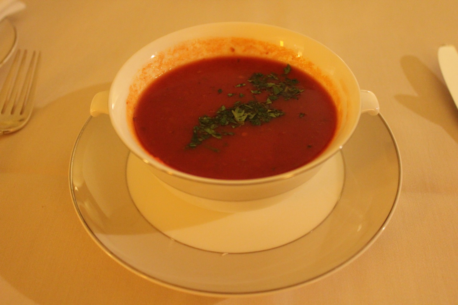 a bowl of soup with a saucer and a plate