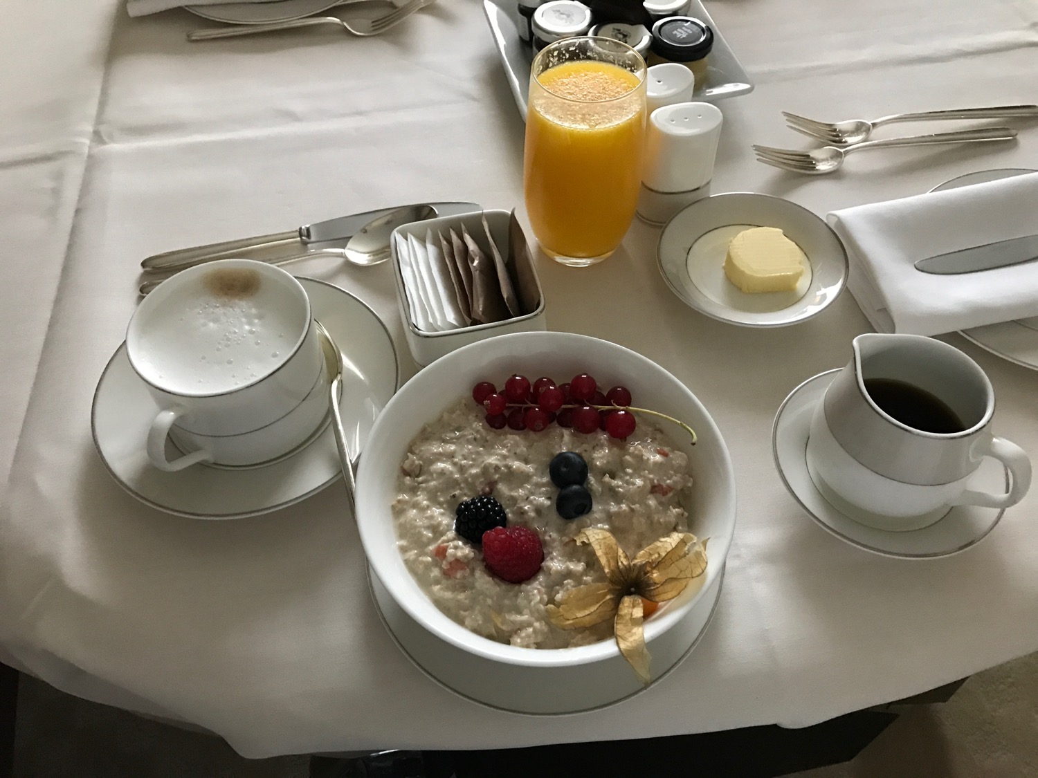 a bowl of oatmeal with berries and a glass of juice