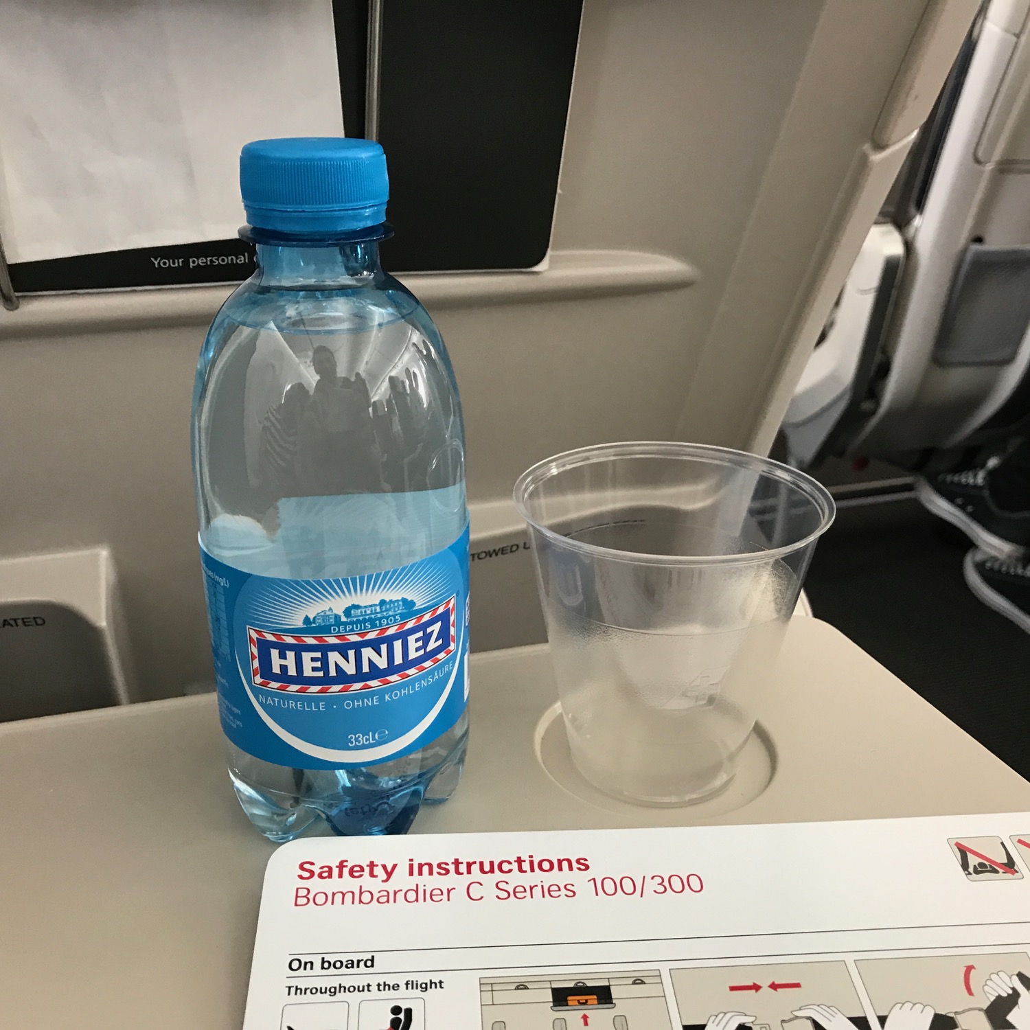 a bottle of water and a plastic cup on a plane
