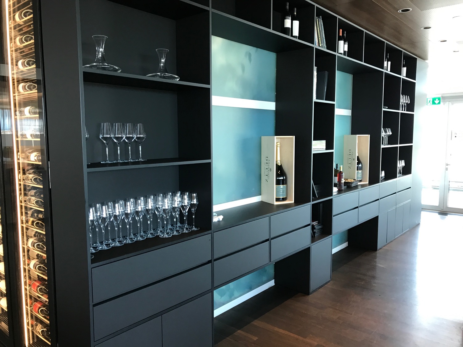 a black shelves with wine glasses and bottles
