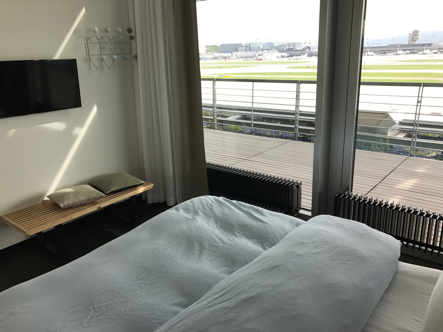 a bed with a view of the runway from the window