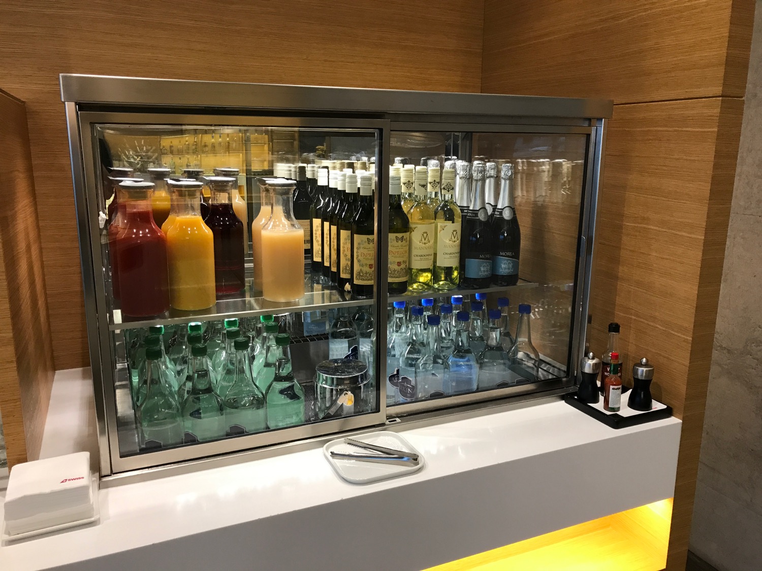 a glass case with bottles of liquid and other beverages