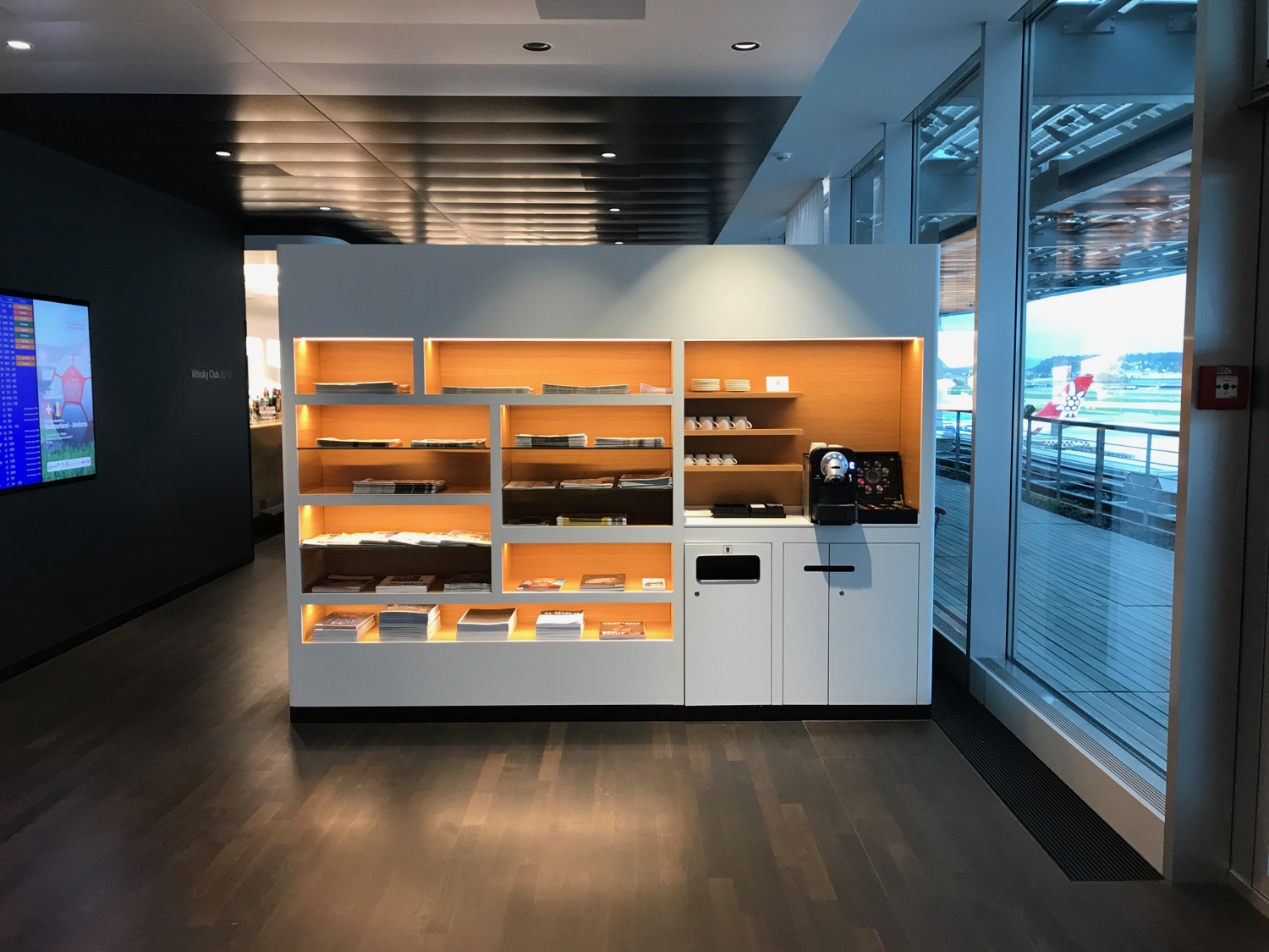 a white shelves with orange lights in a room with windows
