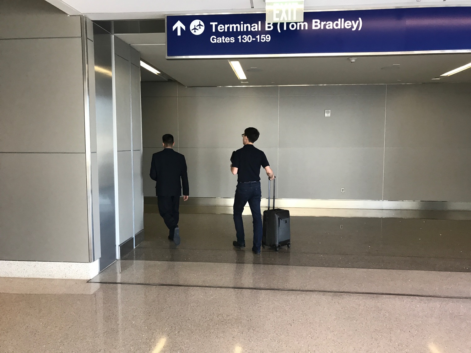 two men walking in an airport