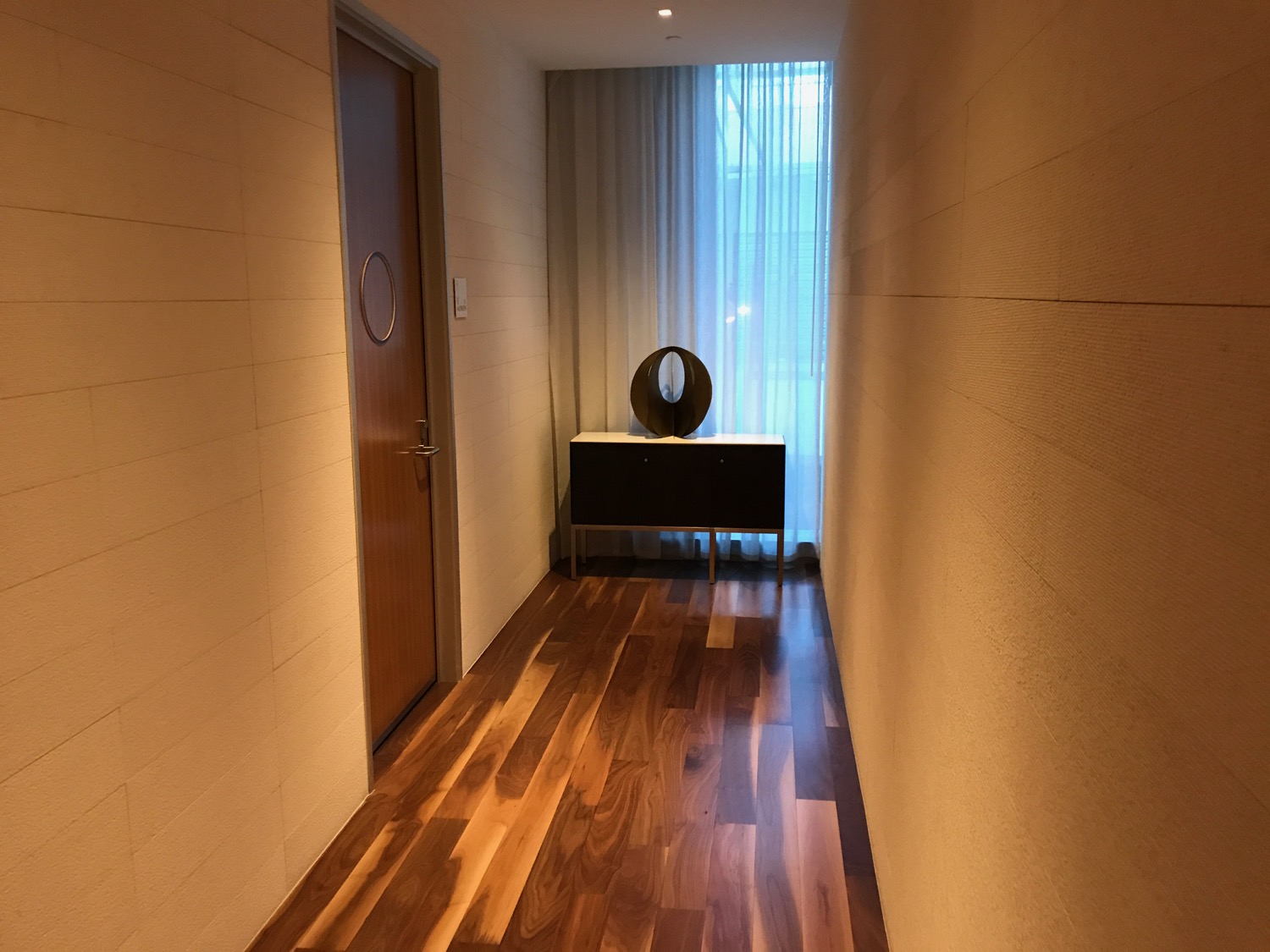 a hallway with a wood floor and a table