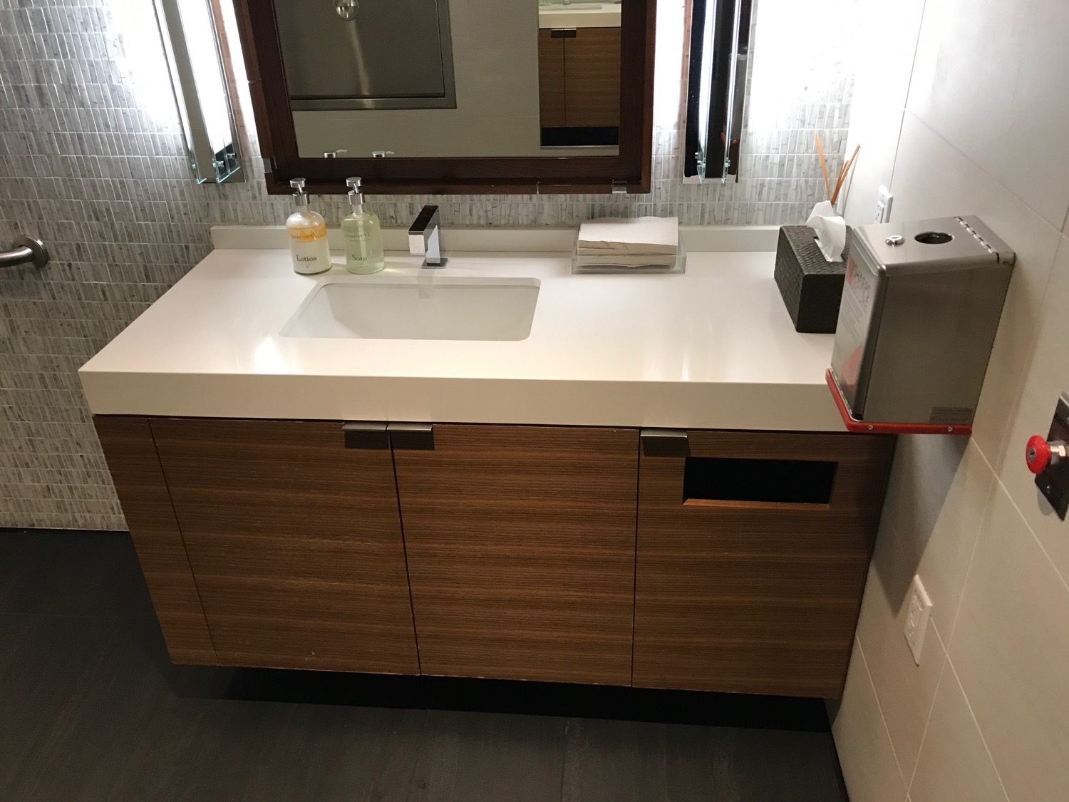 a bathroom sink with a mirror and a wood cabinet