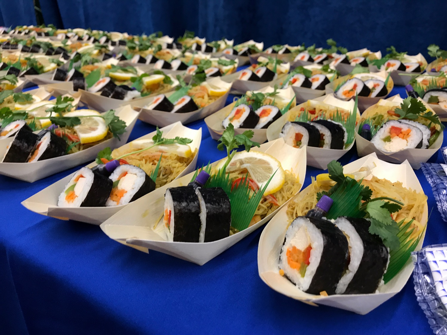 a row of sushi boats on a table