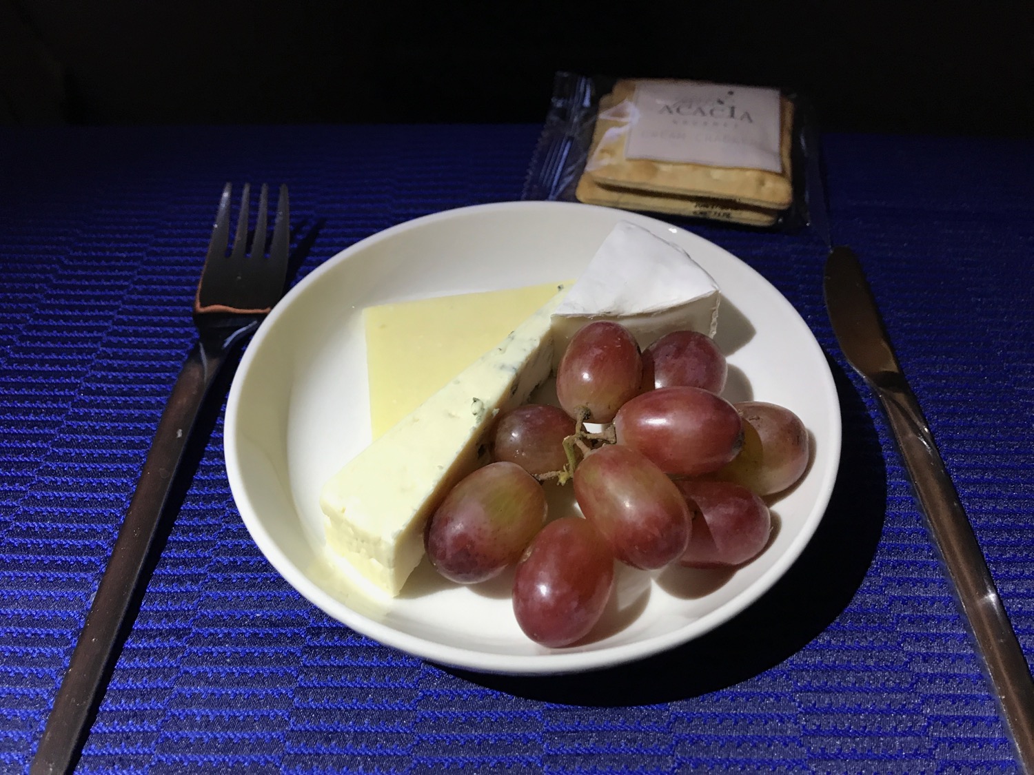 a plate of cheese grapes and a knife
