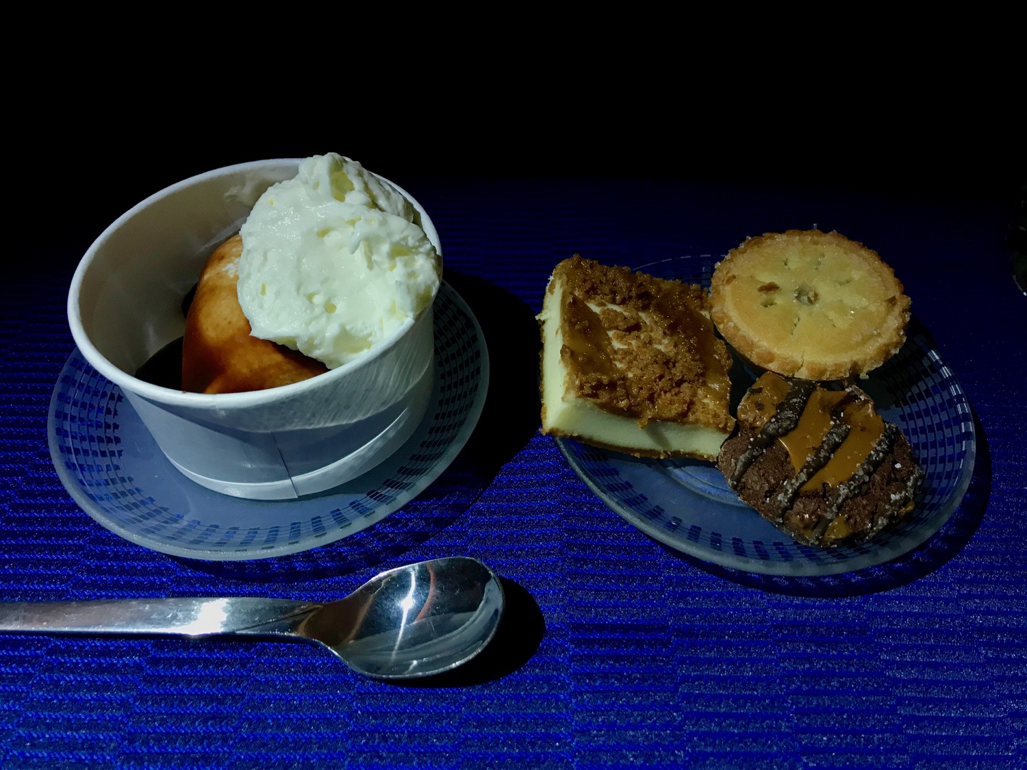 a cup of ice cream and cookies on a plate