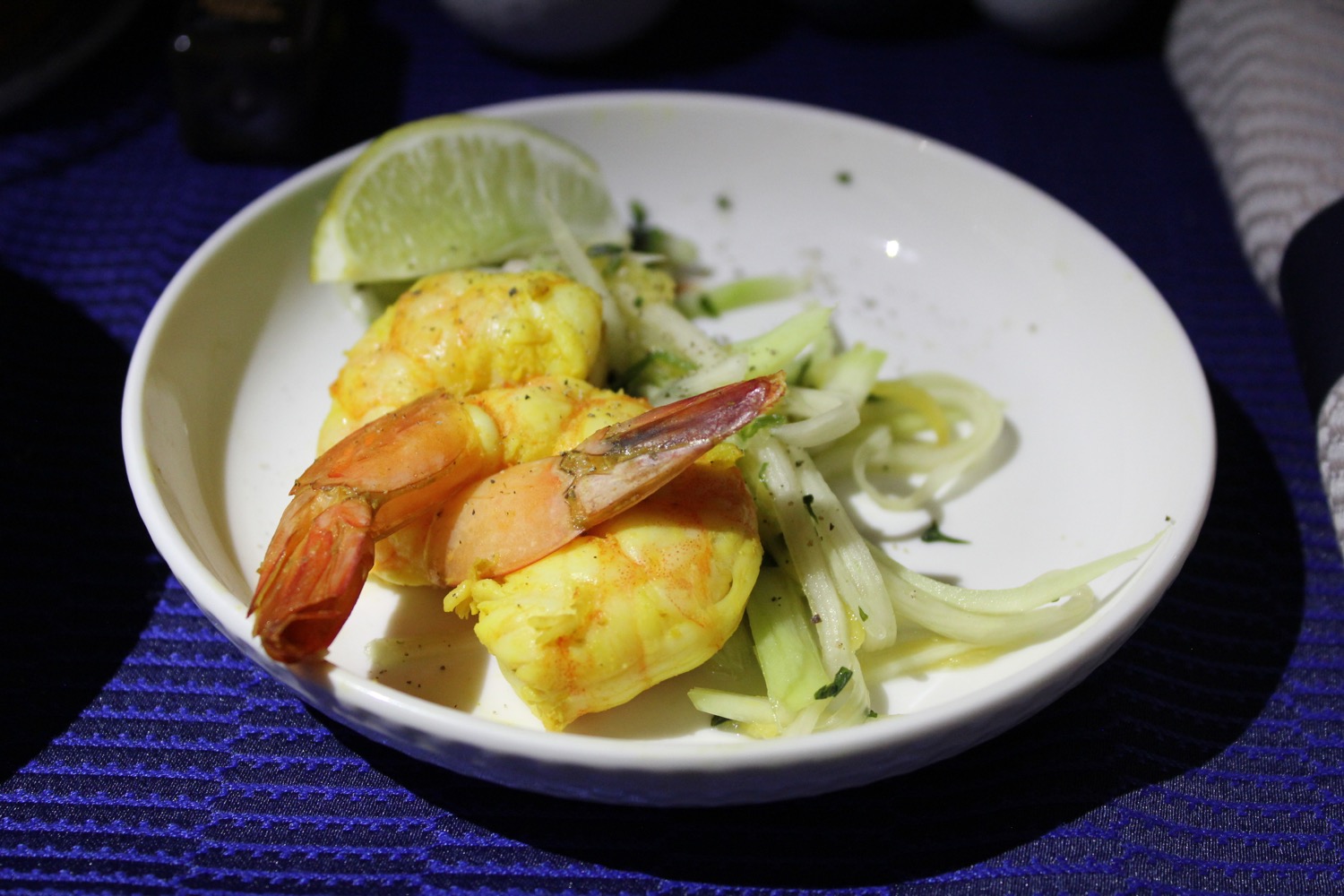 a plate of food with shrimp and lime wedges