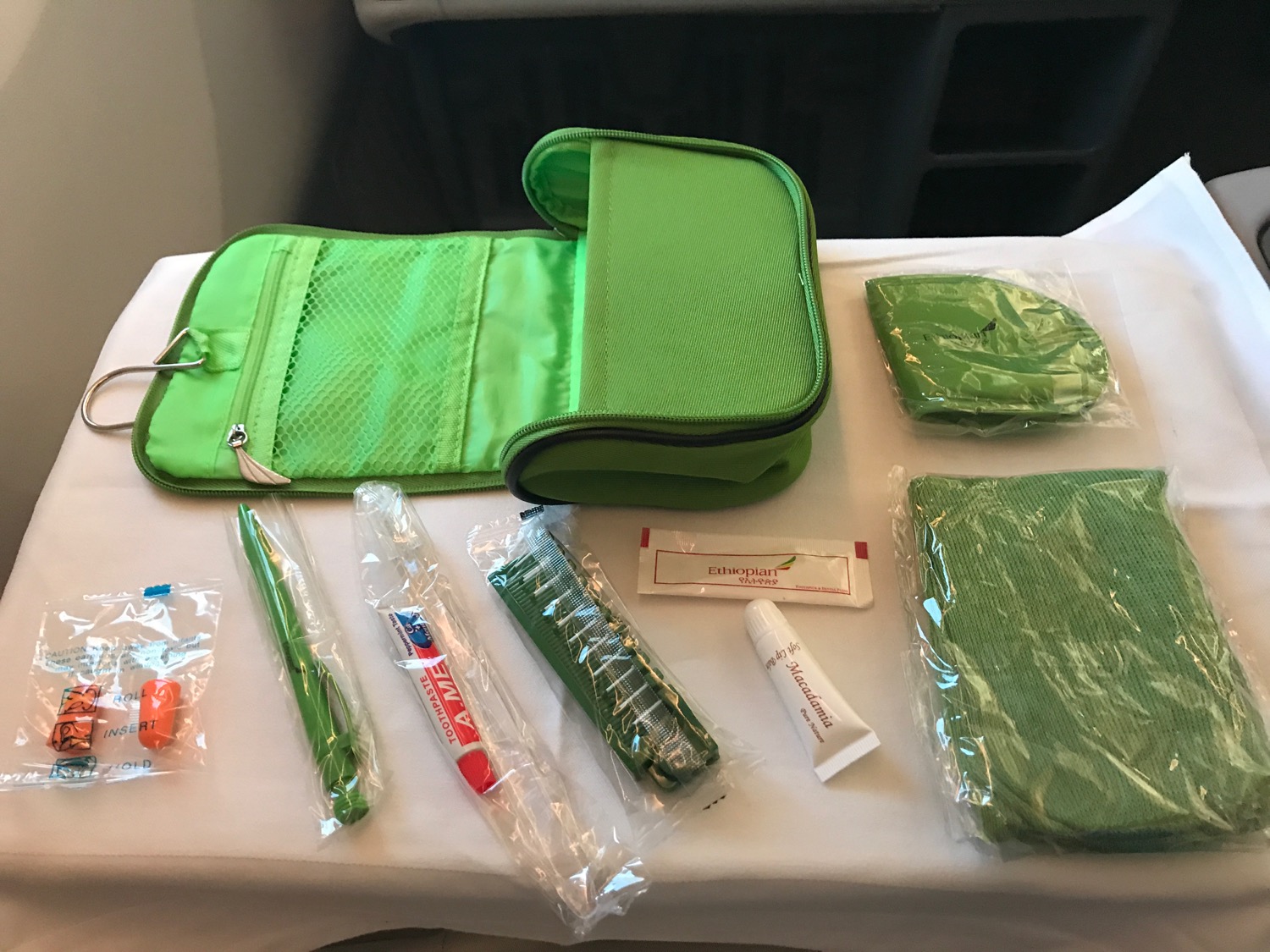 a green bag with a few items on a table
