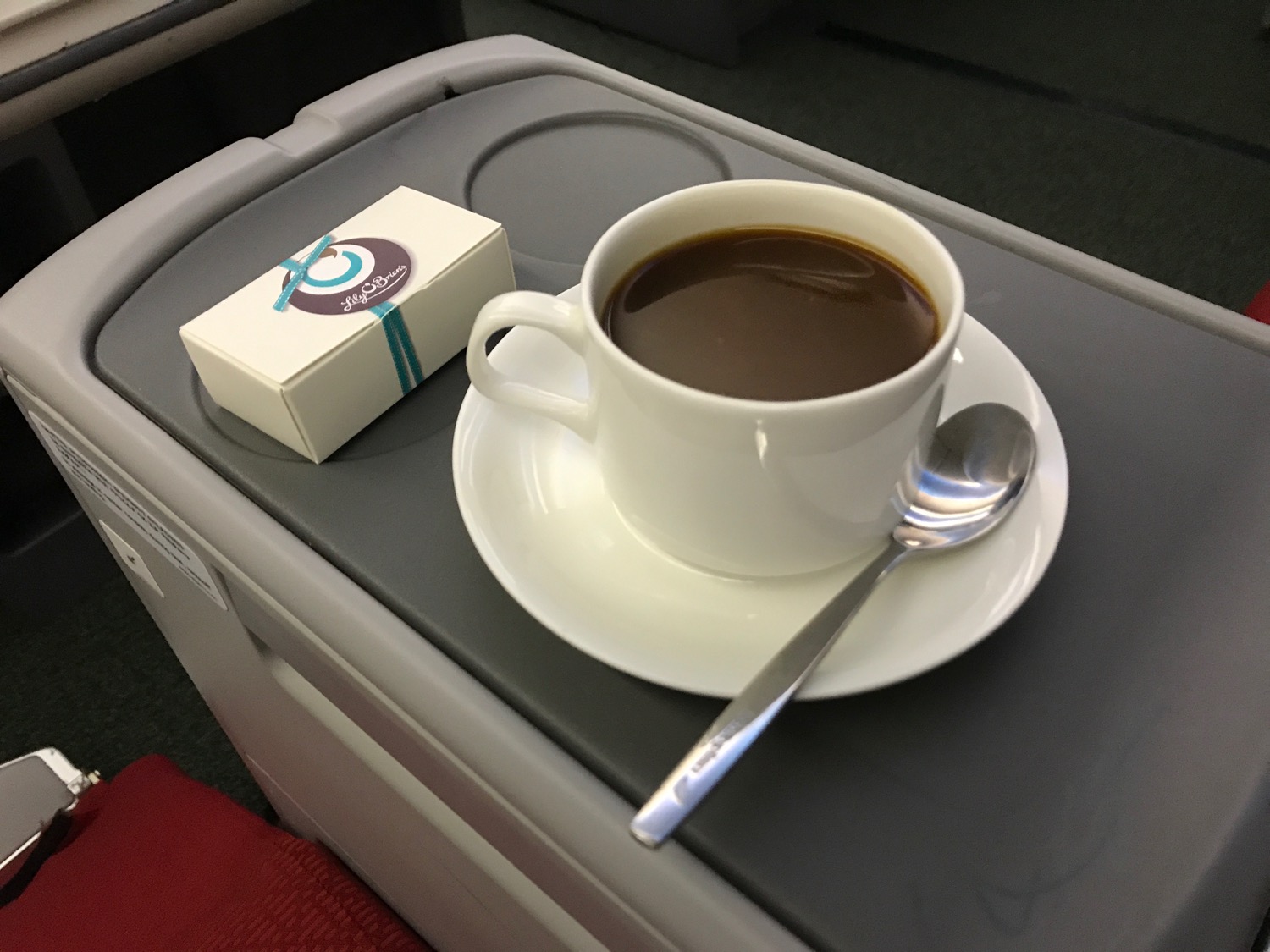 a cup of coffee and a small box on a tray