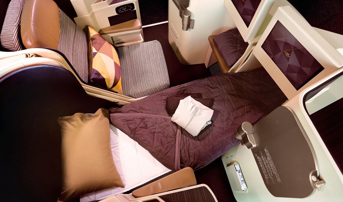 a bed and chairs in a plane