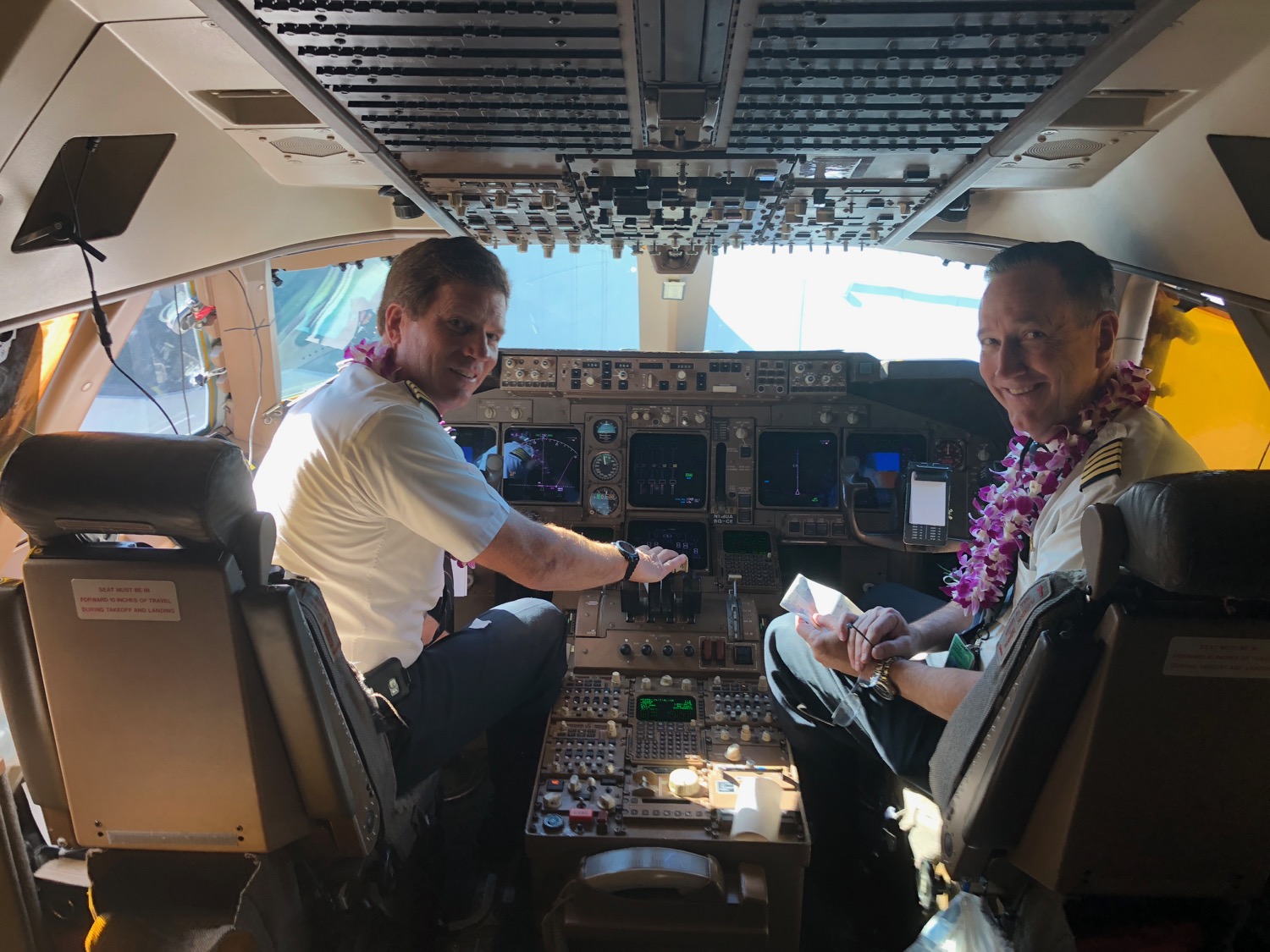 two men sitting in the cockpit of an airplane