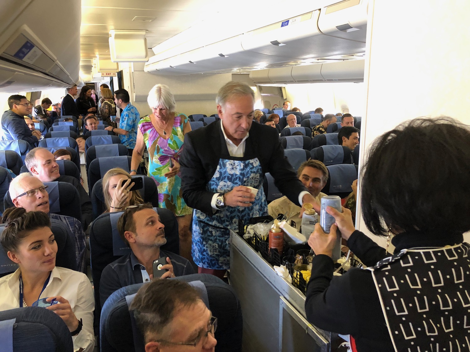 a man standing in an airplane with people around him