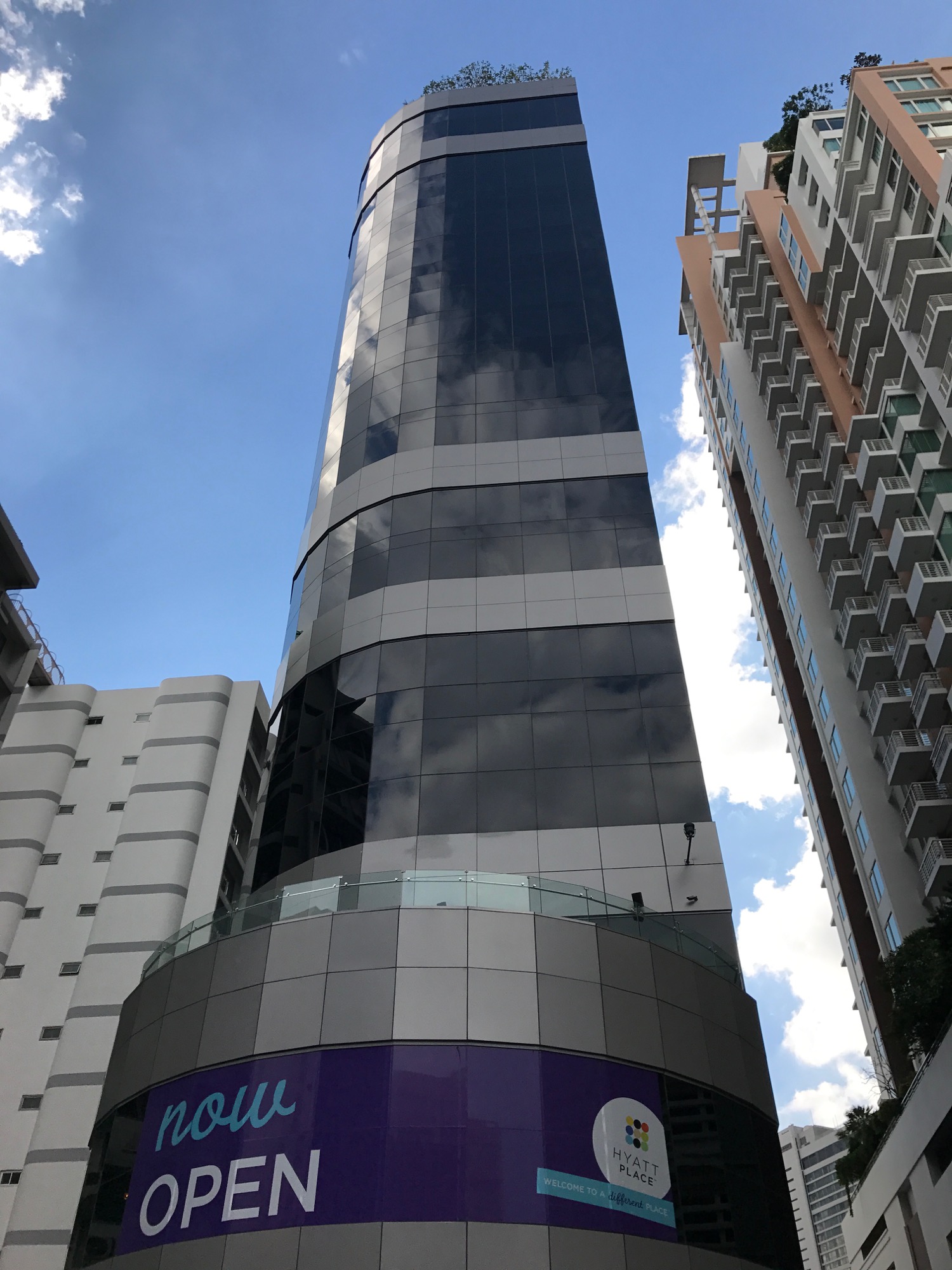 a tall building with a purple sign on the side