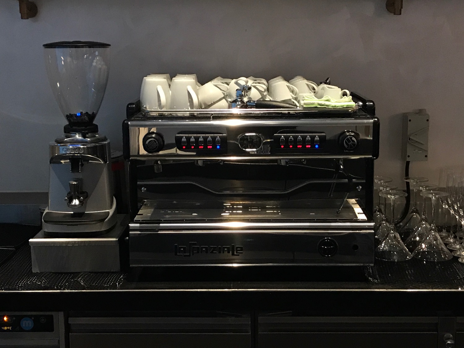 a coffee machine with a group of white cups on top