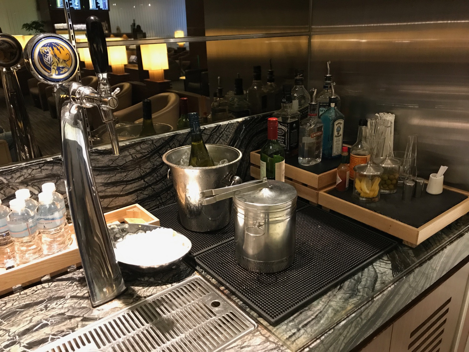 a bar counter with a tap and bottles